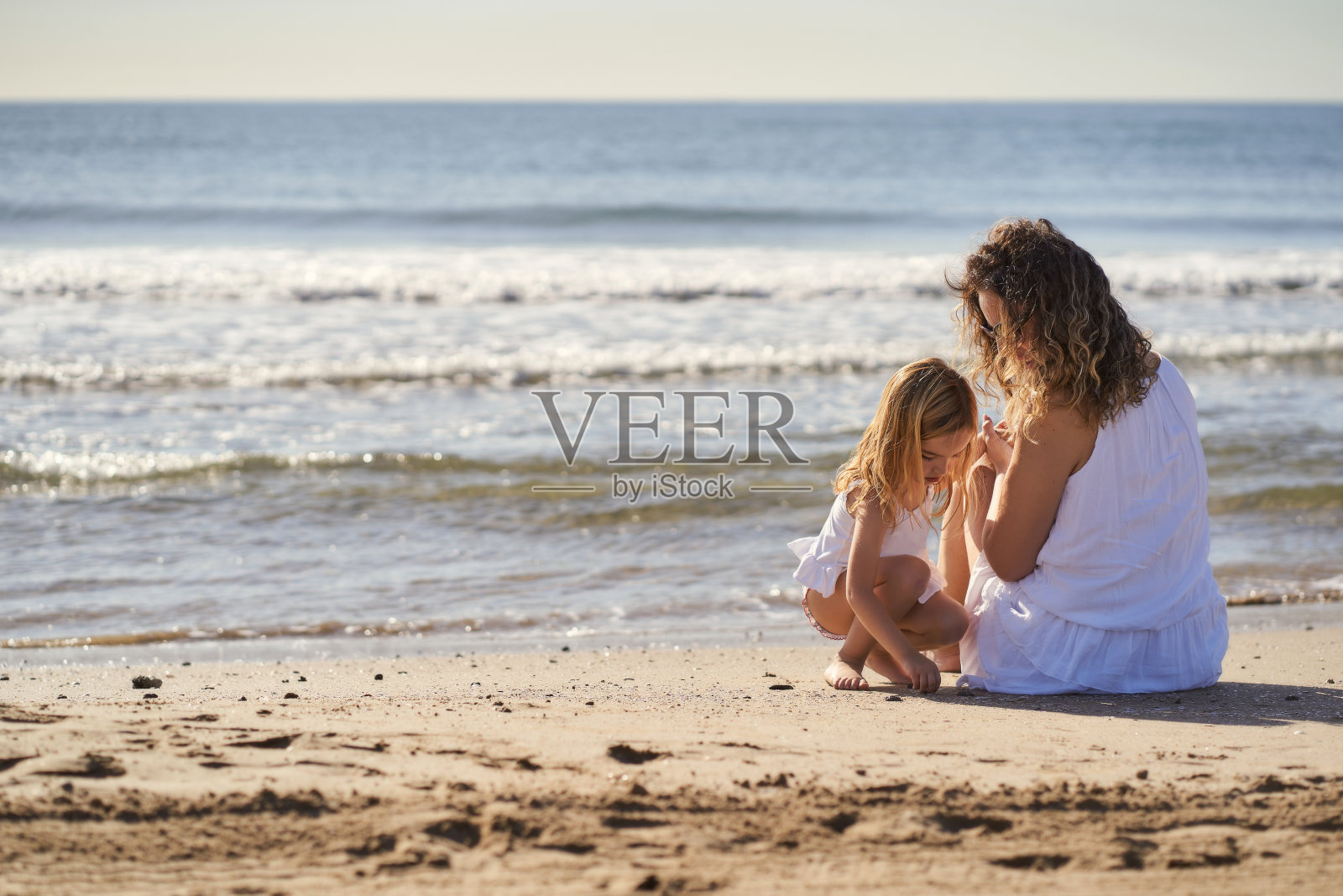 一个女人和她的女儿在海边照片摄影图片