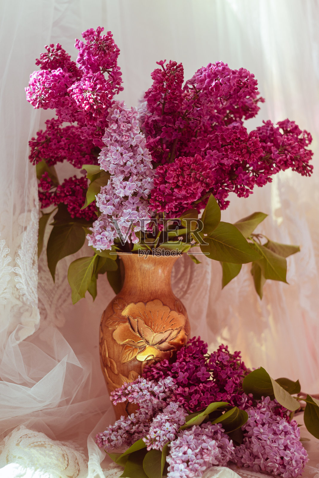 在白色背景的花瓶里，一束鲜艳的紫丁香照片摄影图片