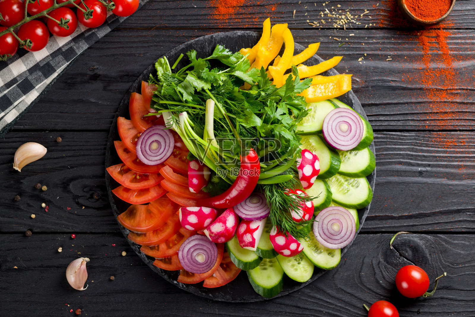 切新鲜蔬菜在一个深色的石头盘子上俯瞰木桌照片摄影图片