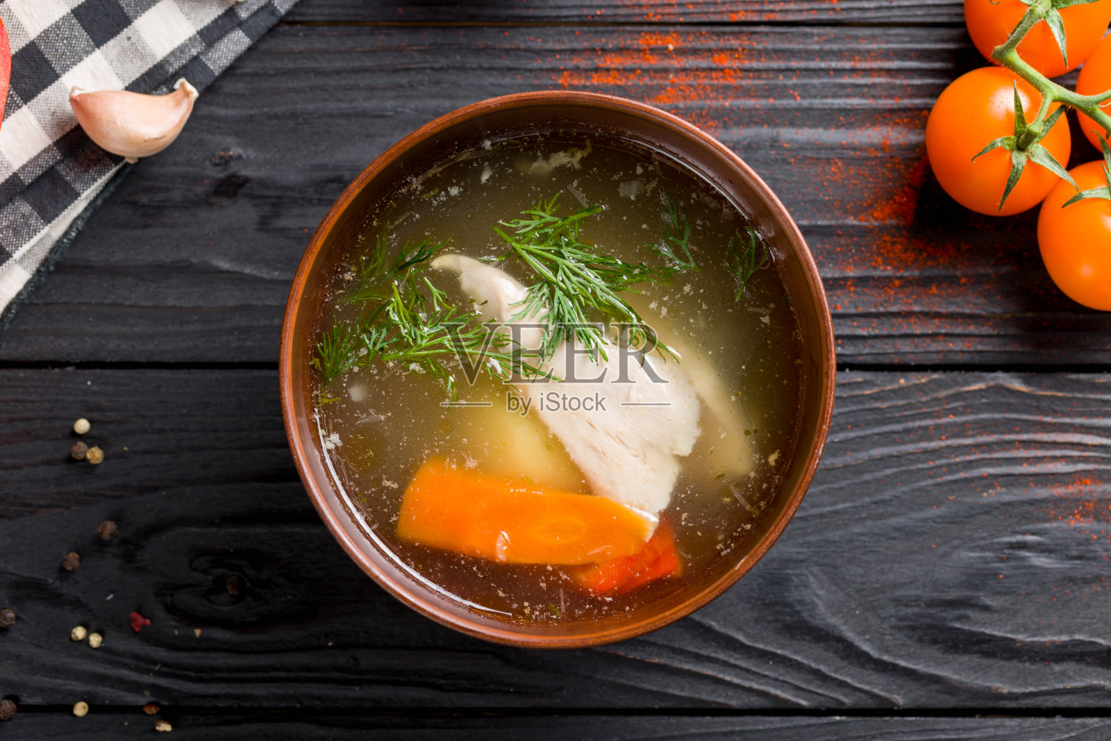 鸡汤配蔬菜和鸡肉，碗放在深色的木桌上照片摄影图片