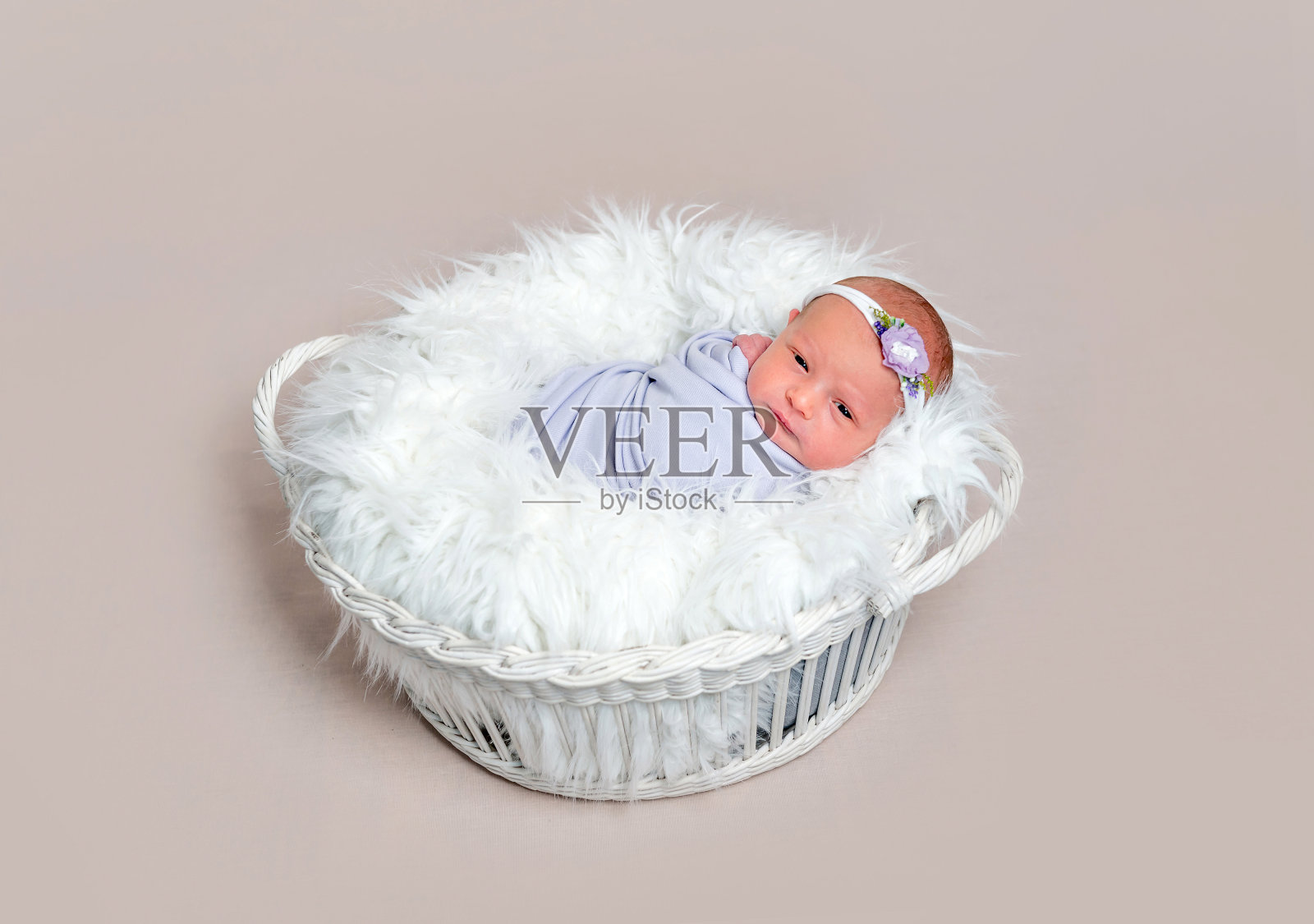 可爱的新生女婴裹在紫色的茧里照片摄影图片