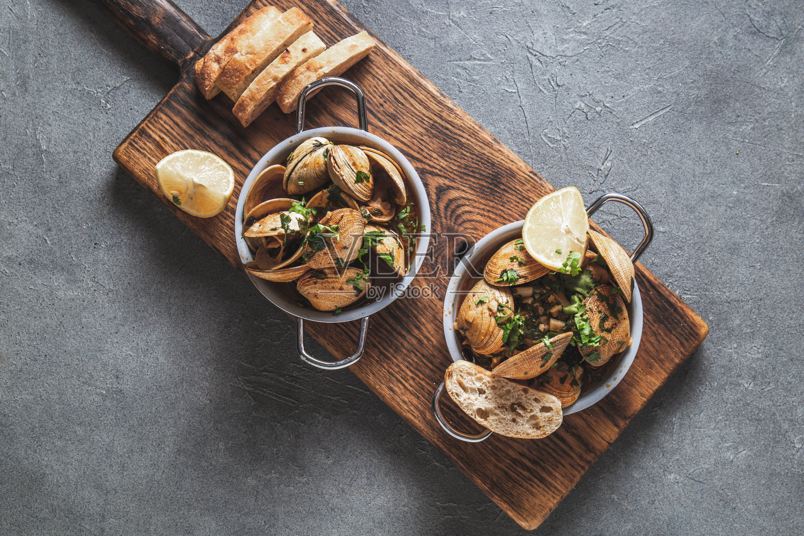 两锅蛤蜊，白葡萄酒加香草。俯视图照片摄影图片