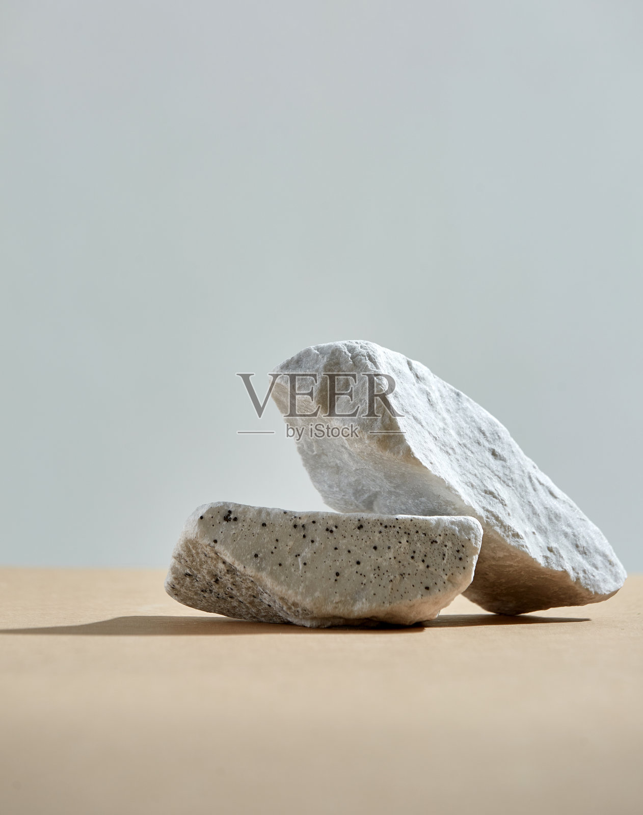 天然裙石。岩石，米色底部，灰色背景。极简主义的化妆品基座。照片摄影图片