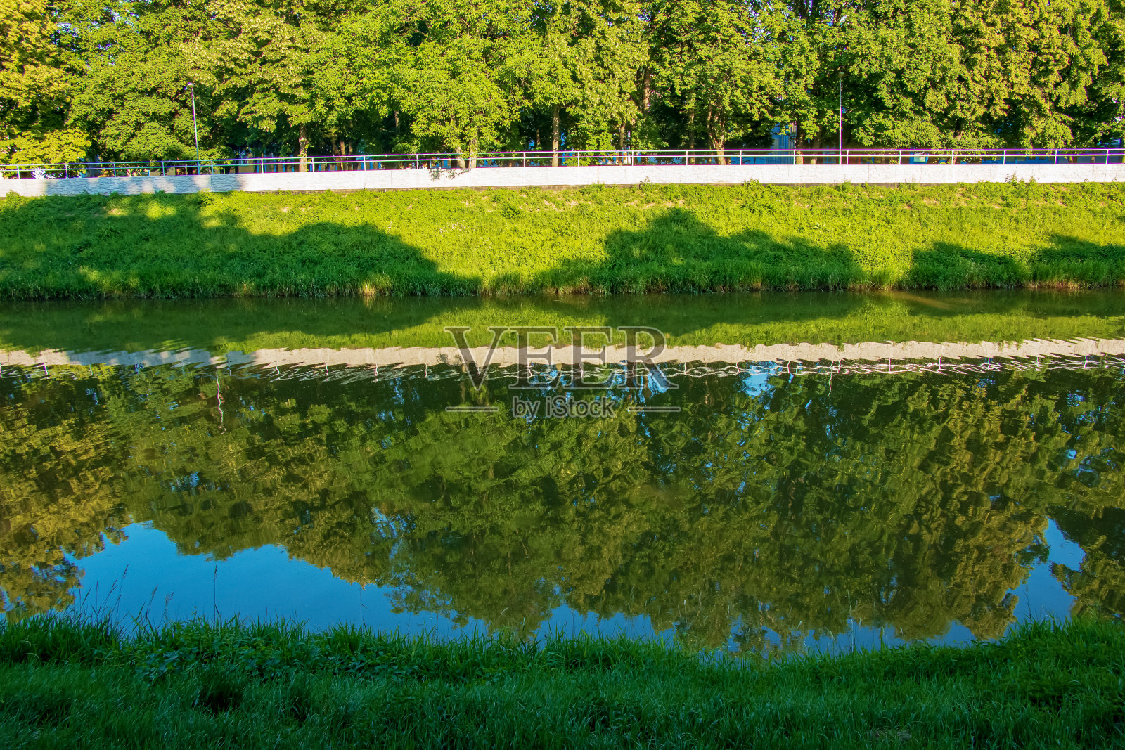 这条河流经这座城市。映照在平静的河岸上。斯洛伐克尼特拉河，阳光明媚的日子。照片摄影图片