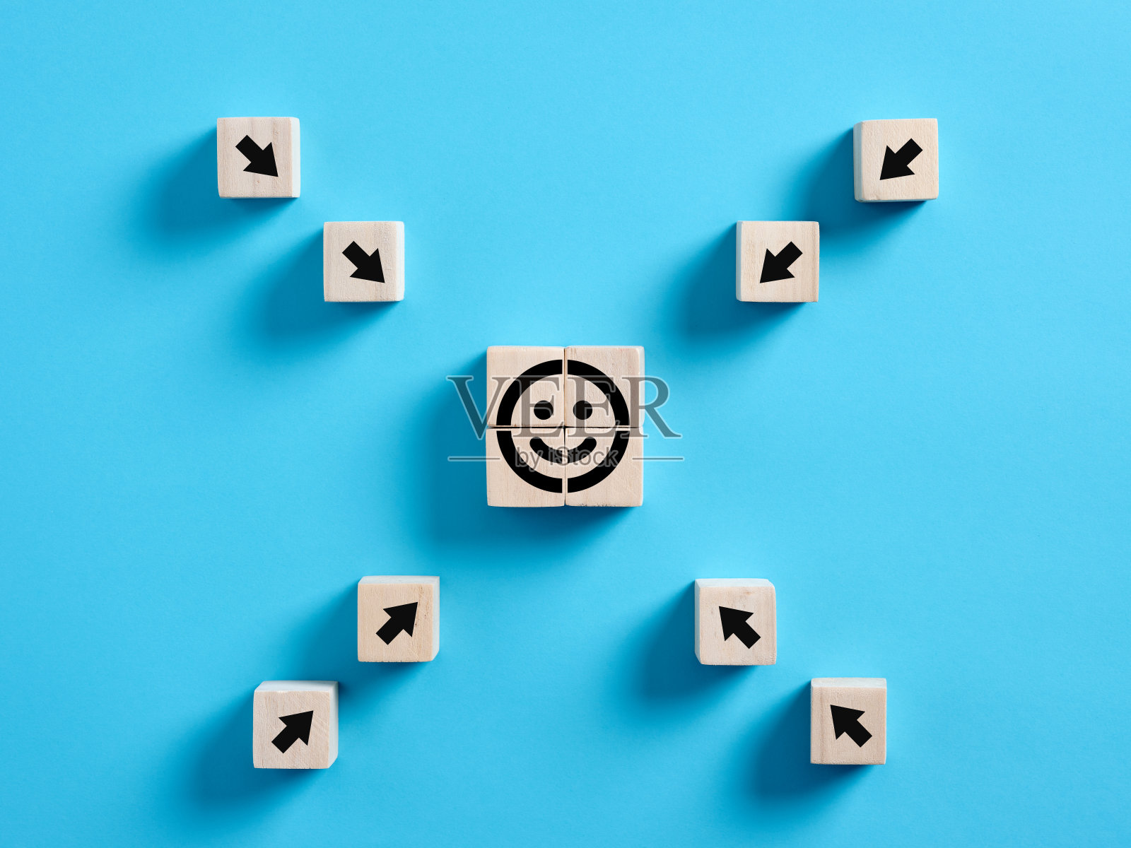 箭头指向木制立方体上的笑脸表情符号。客户满意度、评价或满意客户照片摄影图片