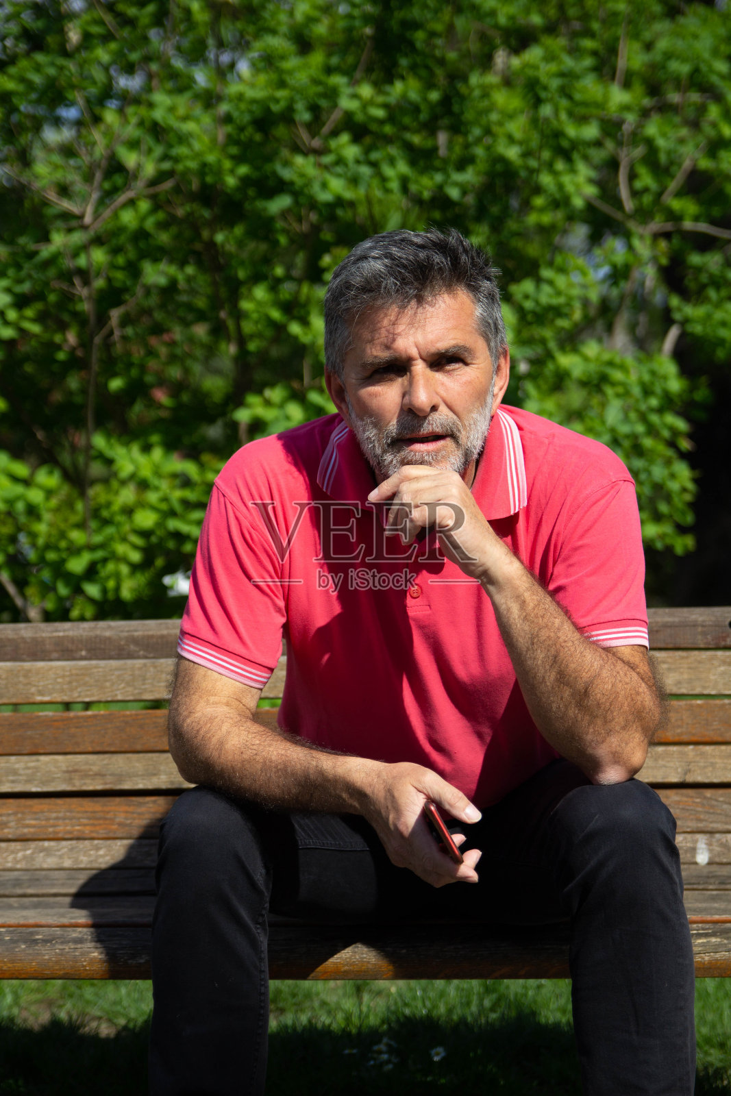 大胡子老人在长凳上等候照片摄影图片