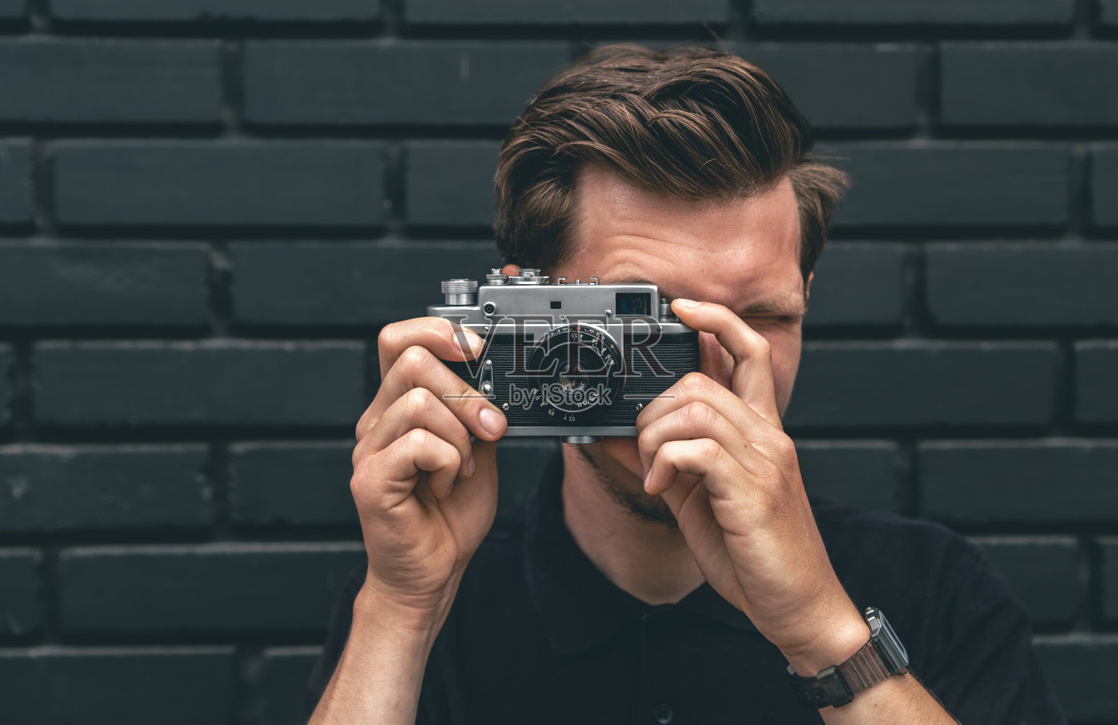 一个年轻人用老式胶卷照相机拍照。照片摄影图片