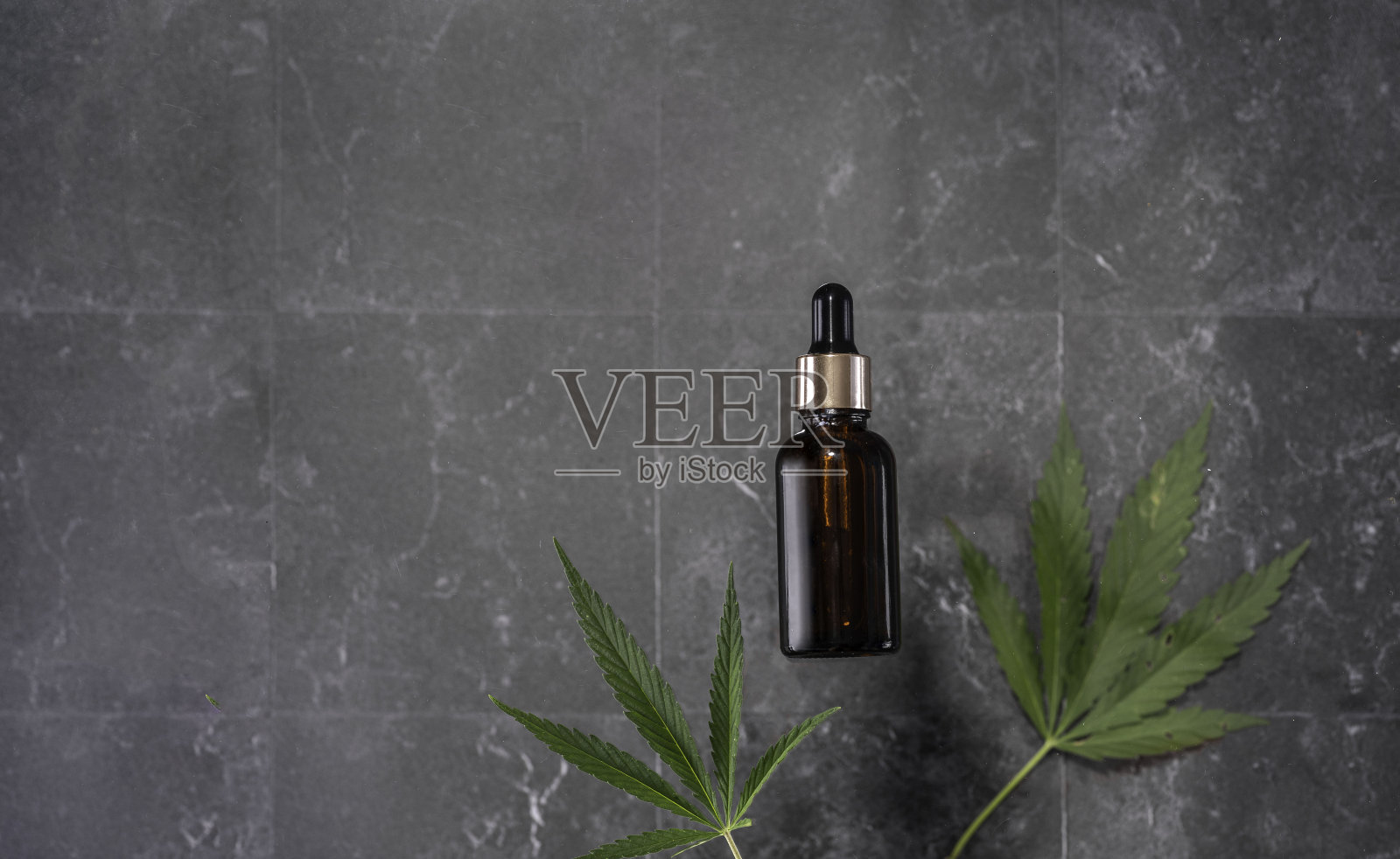 玻璃瓶子，大理石背景上有CBD油，THC酊剂和大麻叶。平坦的躺,极简主义。化妆品CBD。照片摄影图片