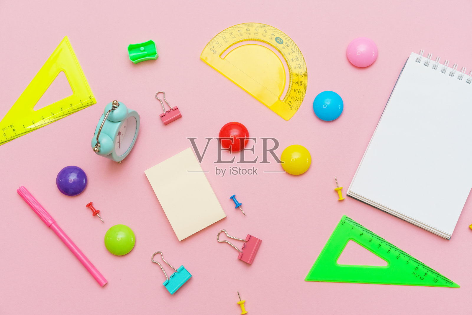 学校用品，文具在粉红色的背景。钢笔铅笔记事本。平躺照片摄影图片