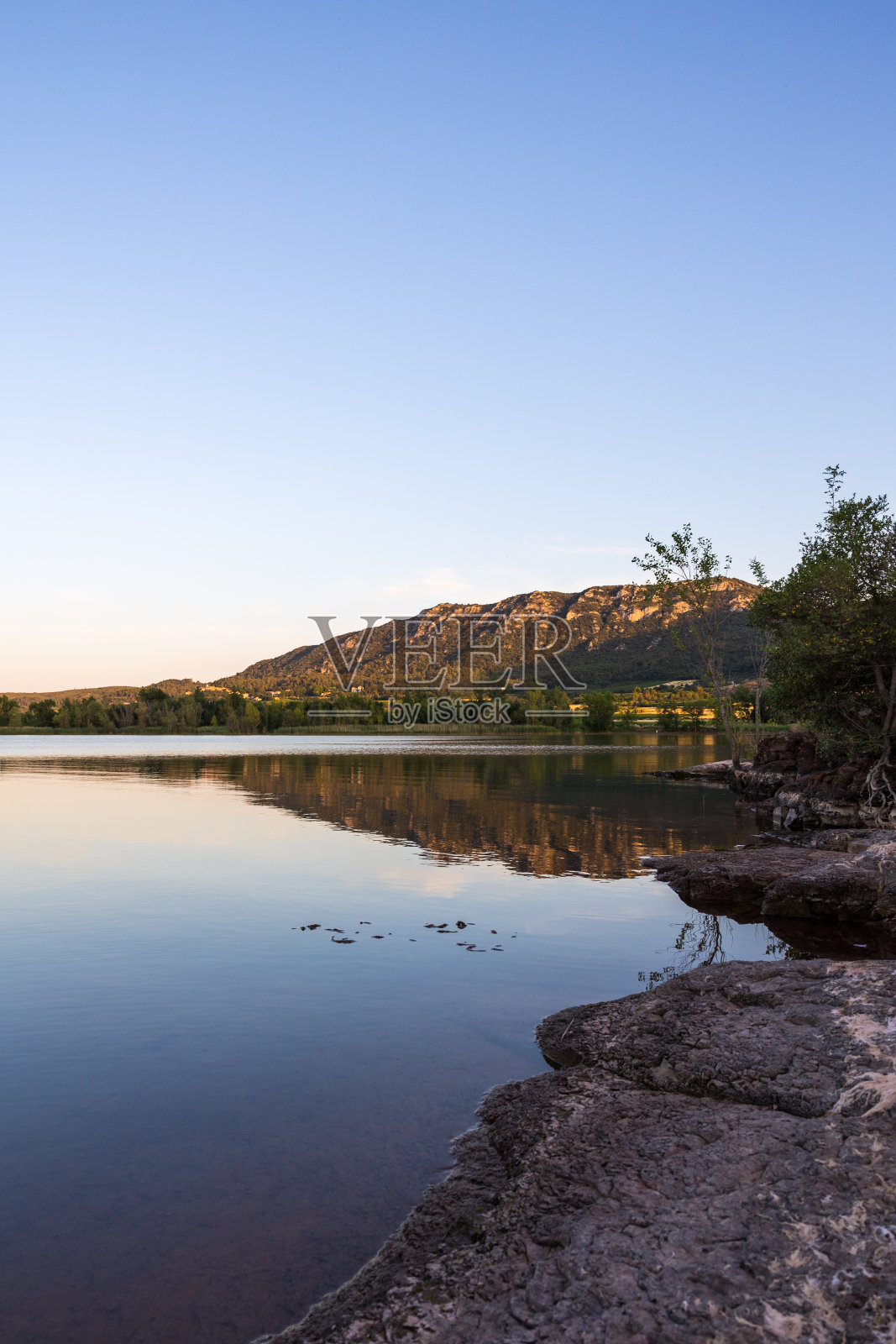 日落时分，在萨拉沟湖畔俯瞰廖松山照片摄影图片