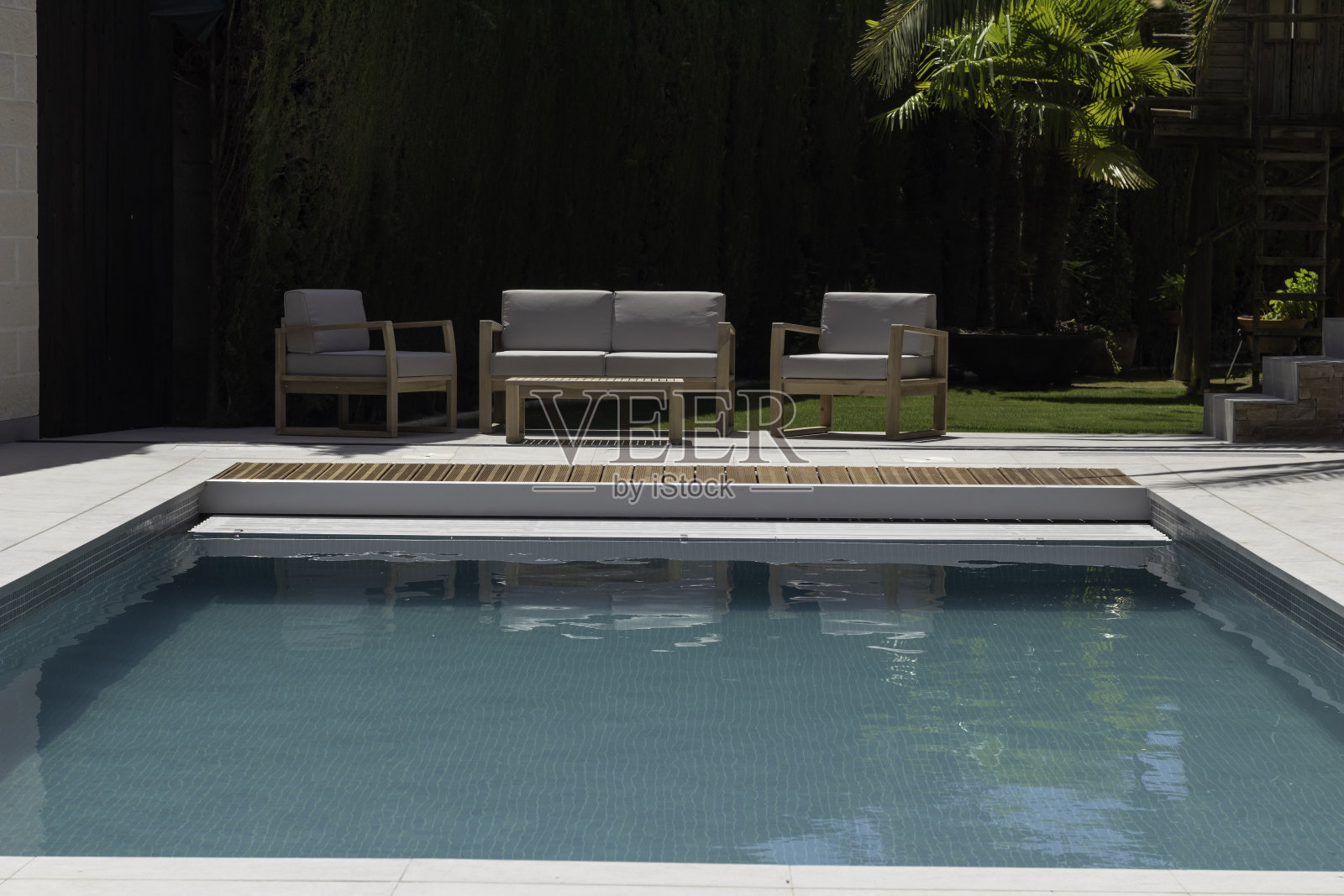 游泳池的前视图与冷峻的休息区和植被在背景中没有人照片摄影图片