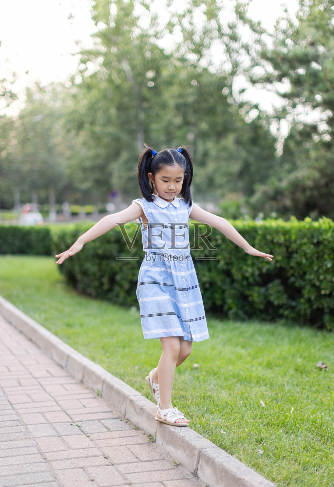 小女孩在平衡木上行走照片摄影图片