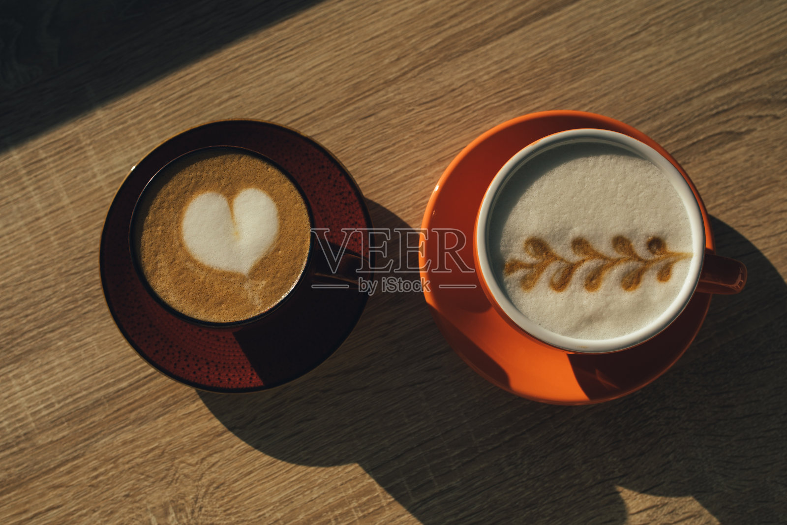 两杯卡布奇诺咖啡放在木桌上。前视图。照片摄影图片