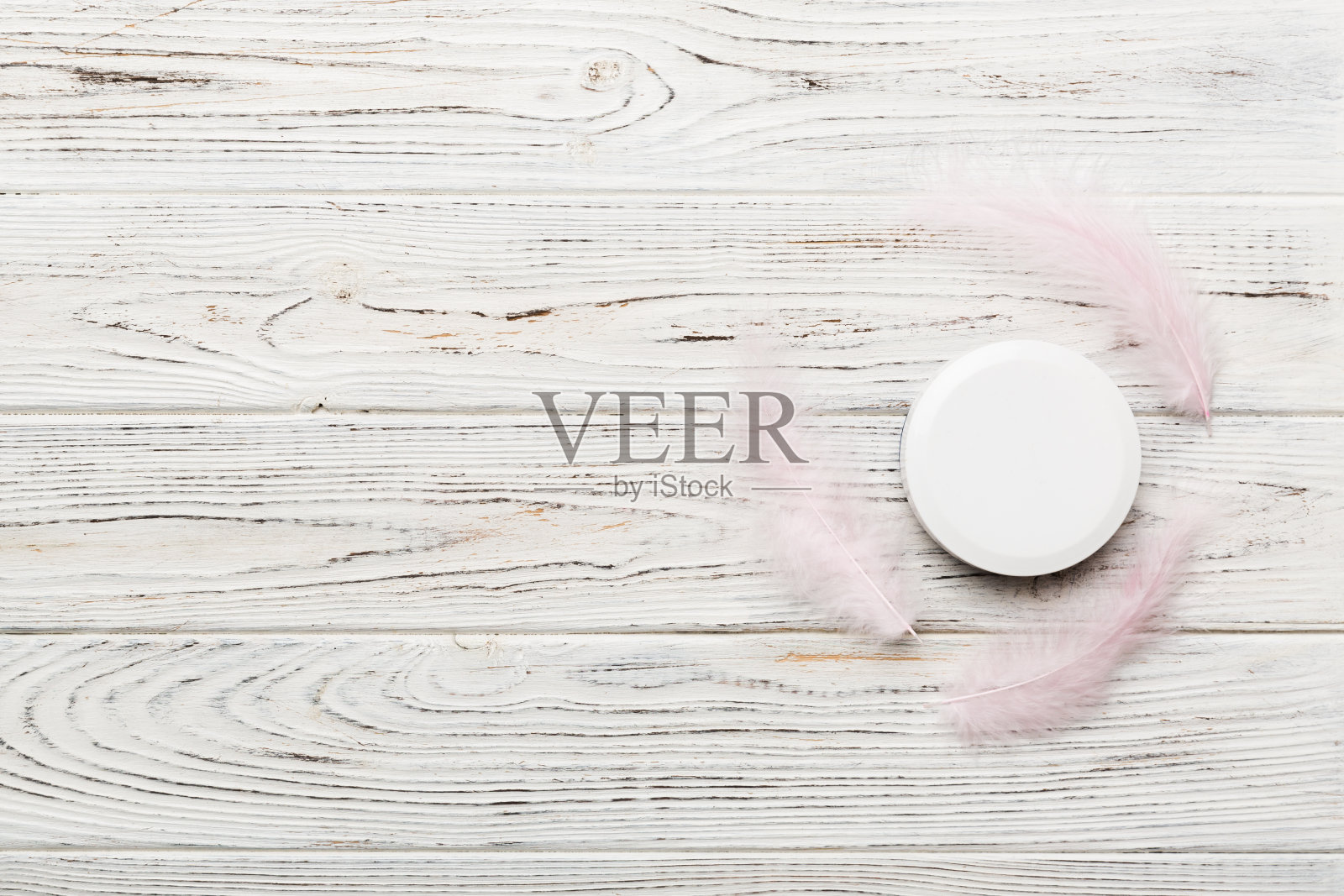 一套皮肤护理血清在粉红色粉彩背景与鸵鸟羽毛。Spa化妆品，奶油罐，品牌模型，顶部视图与复制空间照片摄影图片