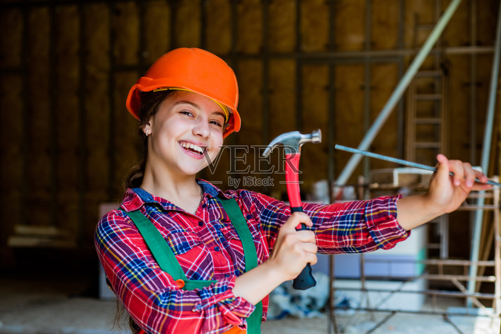 工程教育。未来的工程师。快乐的孩子使用锤子修理工具。建筑工地。孩子建筑师工人。劳动节的概念。儿童的发展。十几岁女孩的助理照片摄影图片