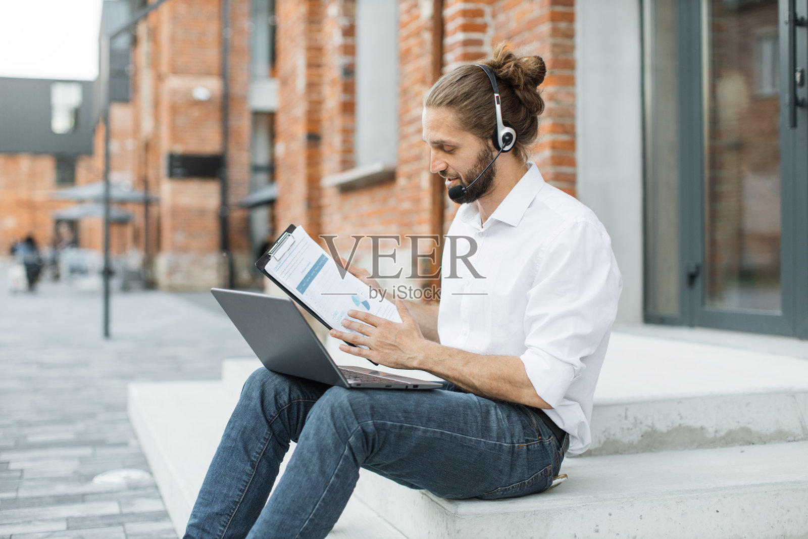 专注有吸引力的经理耳机领导工作会议通过视频电话在笔记本电脑。照片摄影图片