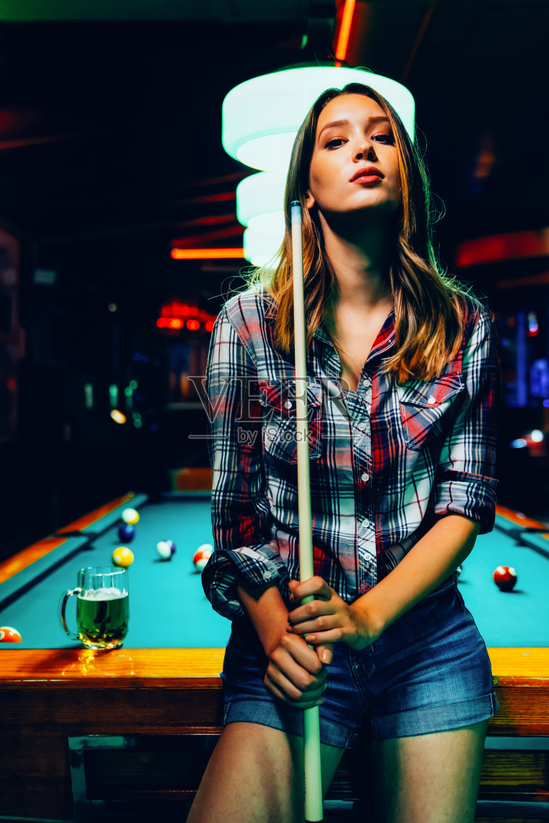 年轻漂亮的女孩在打台球。愉快的消遣、休息、娱乐。照片摄影图片