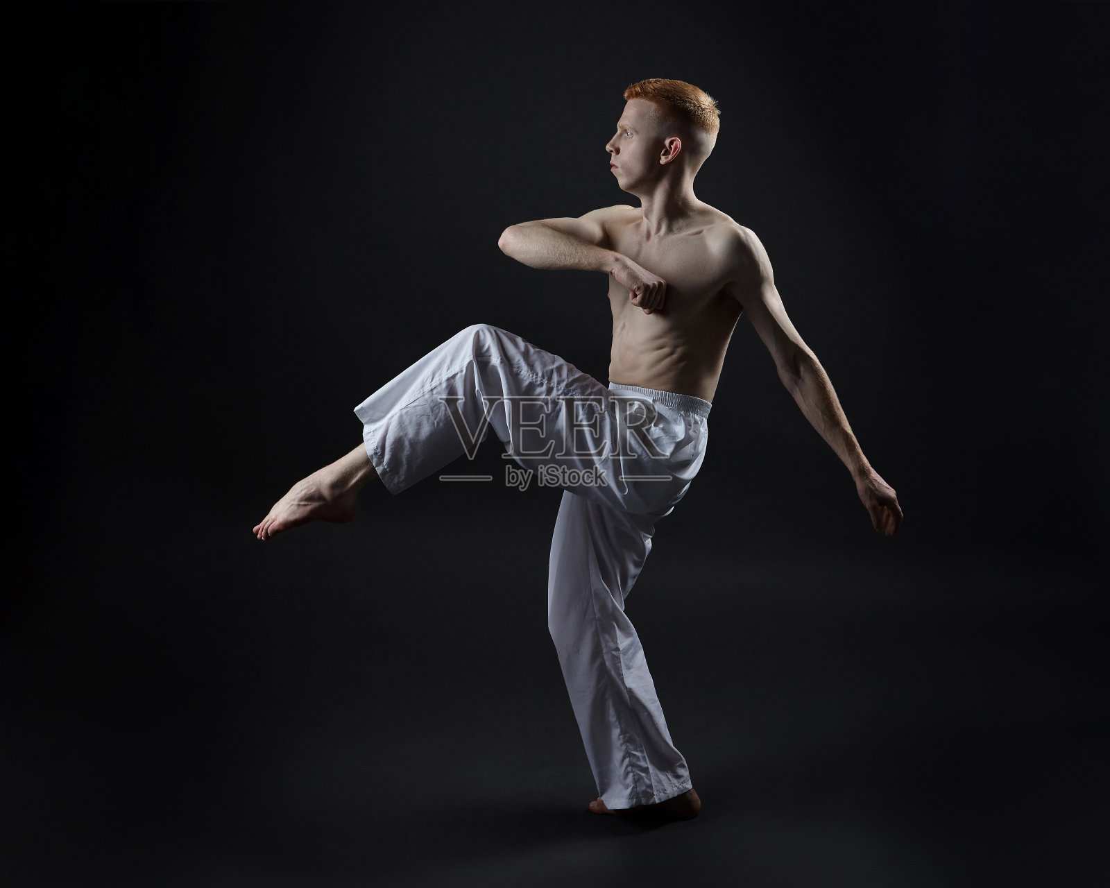 红发男舞者展示舞蹈的舞蹈元素。照片拍摄在工作室的黑色背景照片摄影图片