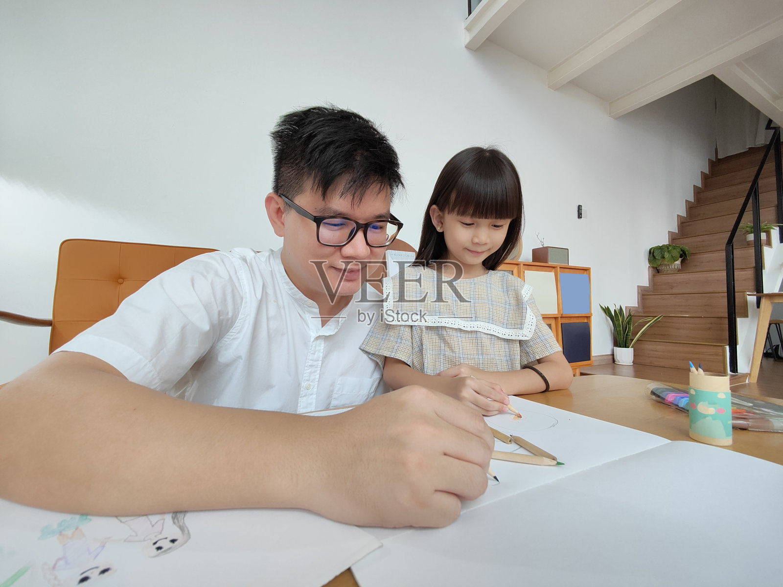 年轻的亚洲父亲和小女儿在客厅一起画画照片摄影图片