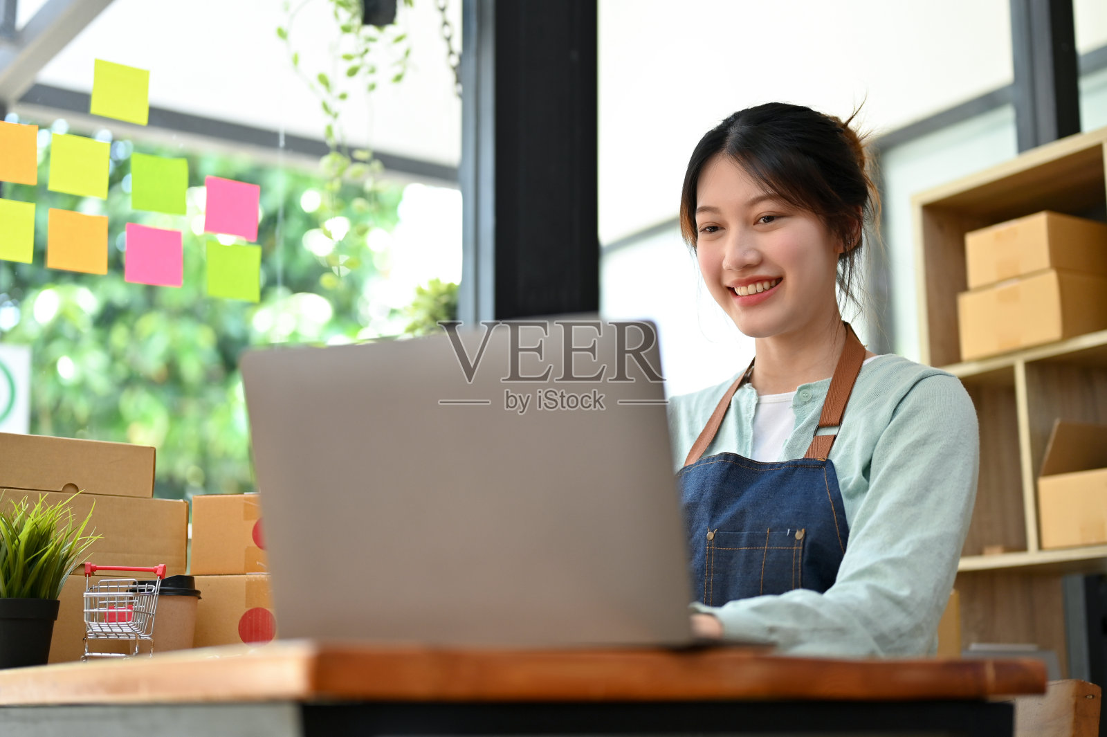 一位女时装店主用笔记本电脑回复顾客的信息照片摄影图片