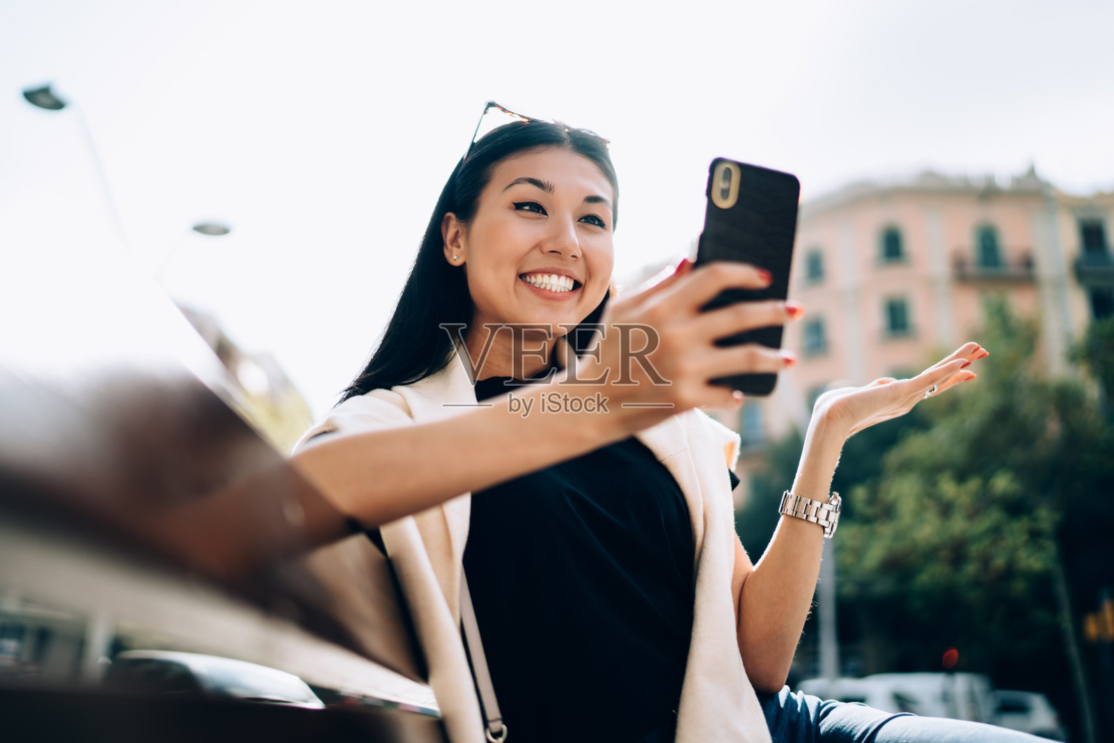 大喜的亚洲女性在休闲服装坐在长凳上浏览信息的智能手机通过4G，快乐积极的女人拿着手机发送短信和邮件在社交网络照片摄影图片