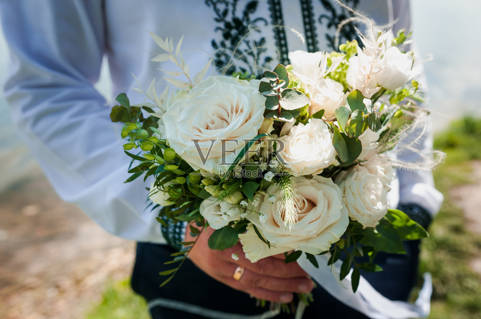 婚礼花束在新郎手中。美丽的新娘花束在一个男人的手中照片摄影图片