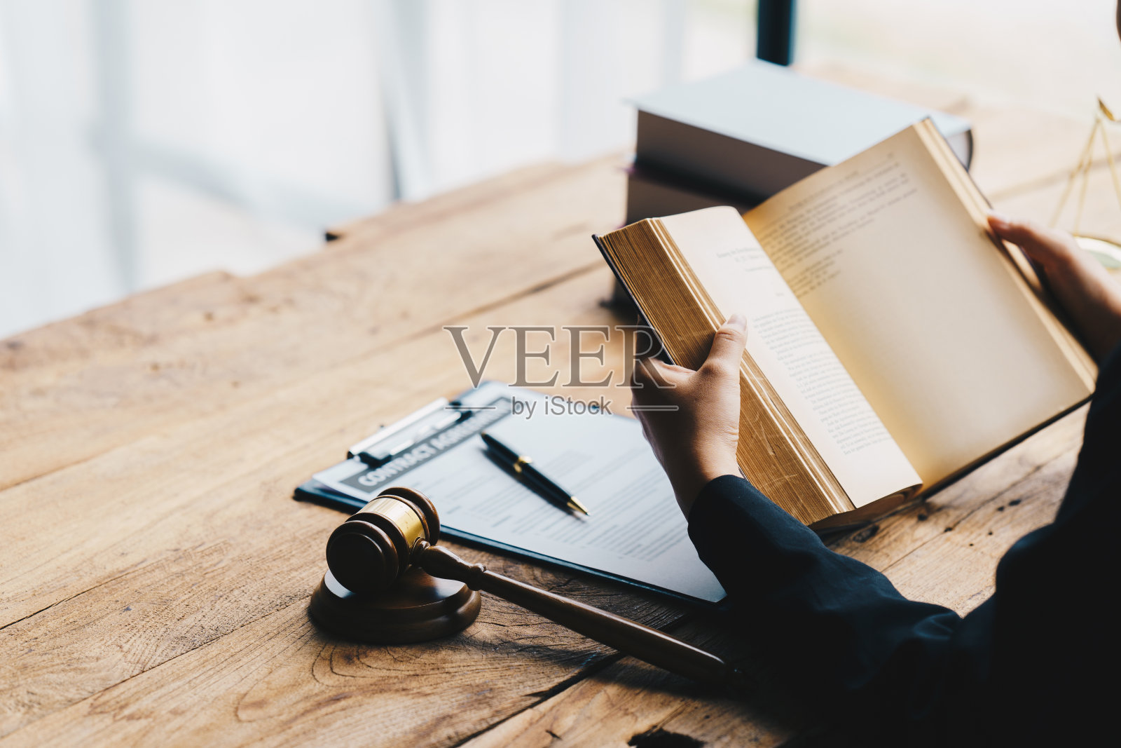 走近律师商人工作或阅读法律书籍的办公室工作场所，咨询律师概念。照片摄影图片