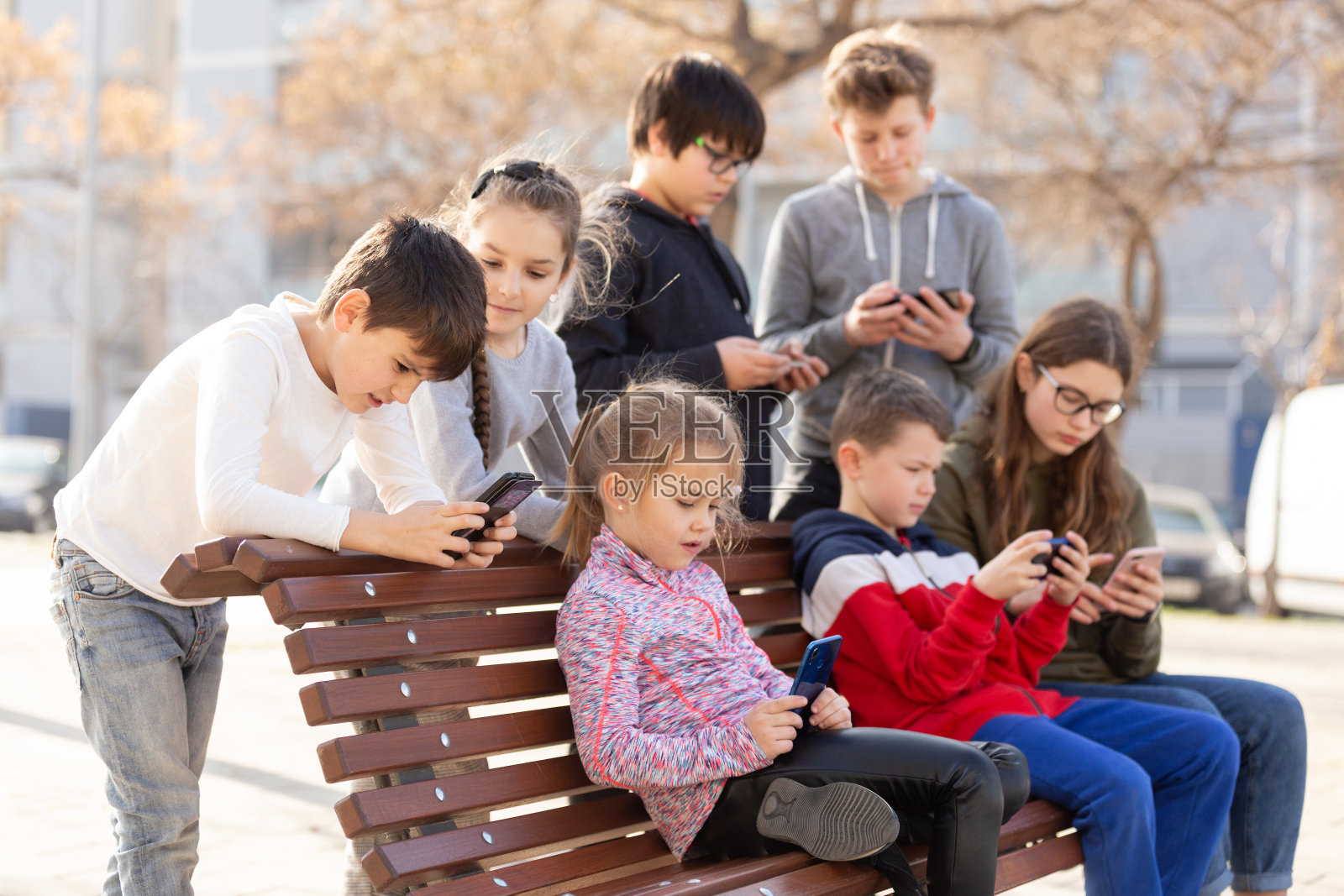 孩子们在户外沉迷于手机照片摄影图片