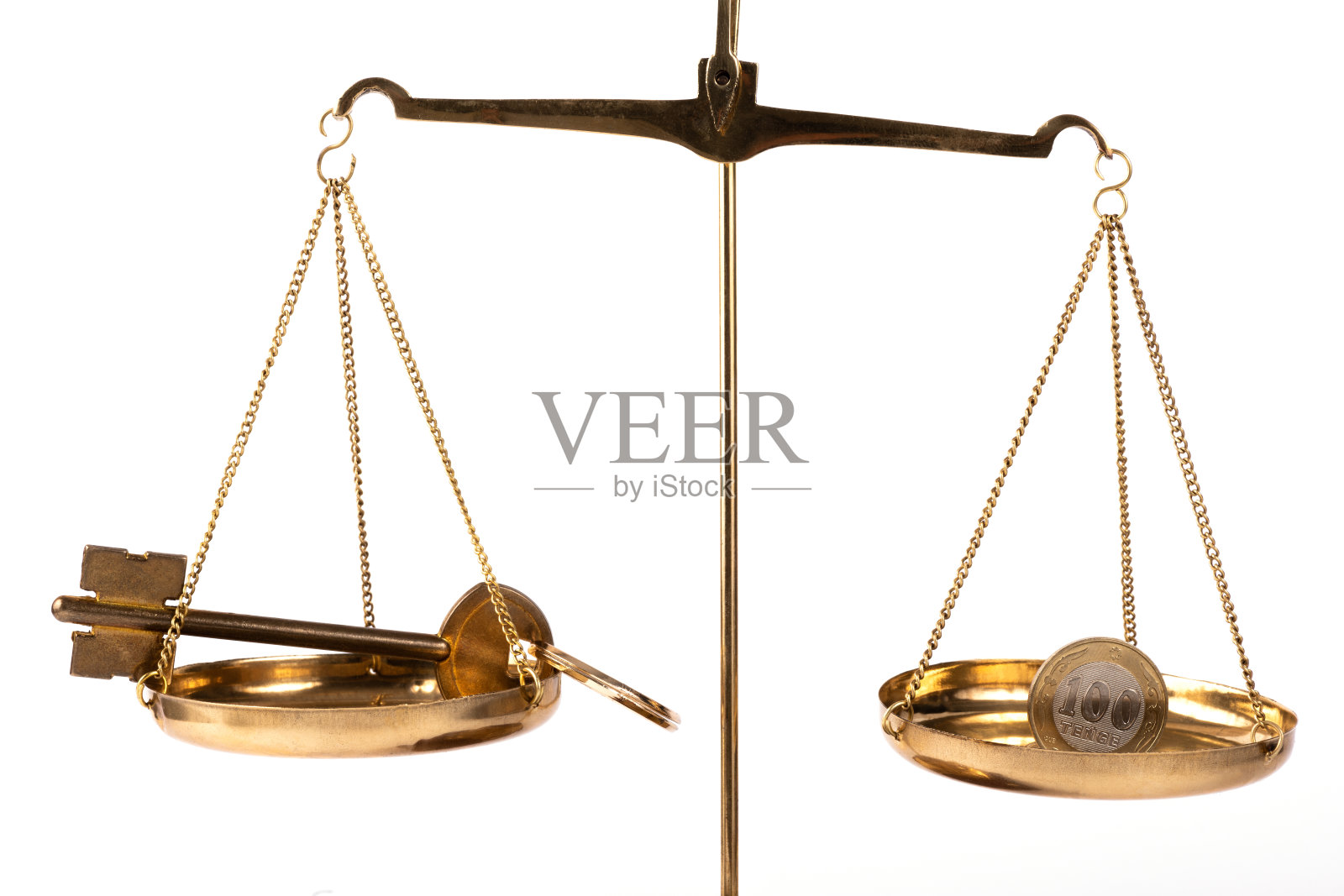 在天平一侧放一枚面值为100哈萨克坚戈的硬币，天平另一侧放一把金钥匙照片摄影图片