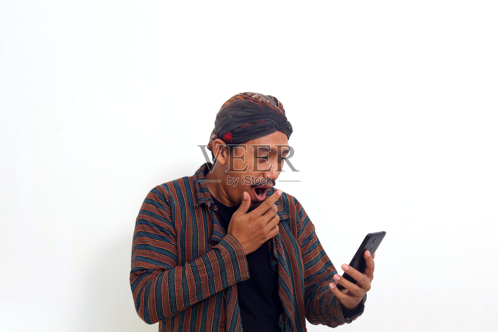 穿着传统服装拿着手机的亚洲男子。孤立在白色背景上照片摄影图片
