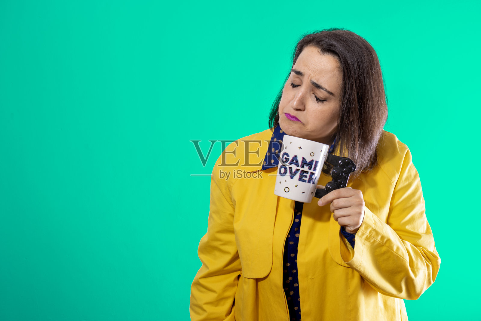 悲伤的年轻女孩与GAME OVER杯子照片摄影图片