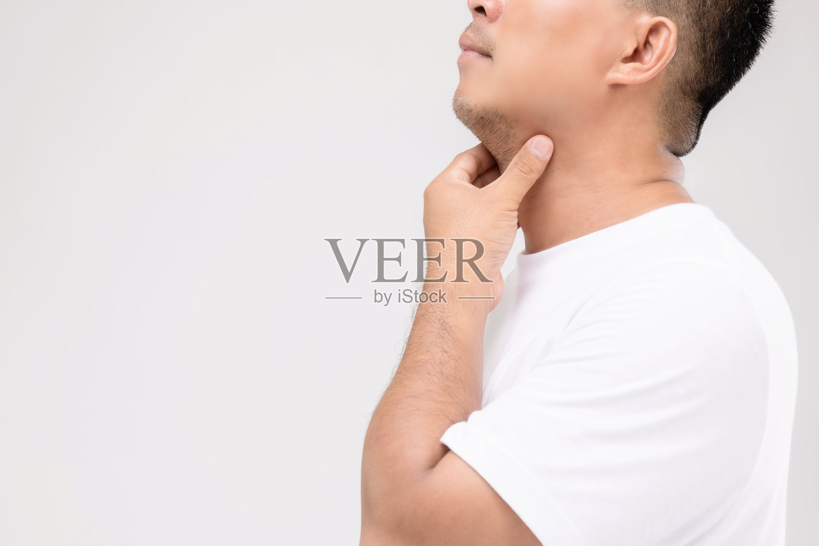 男性淋巴瘤概念:肖像亚洲男性触摸他的颈部淋巴结位置。工作室拍摄孤立的灰色照片摄影图片