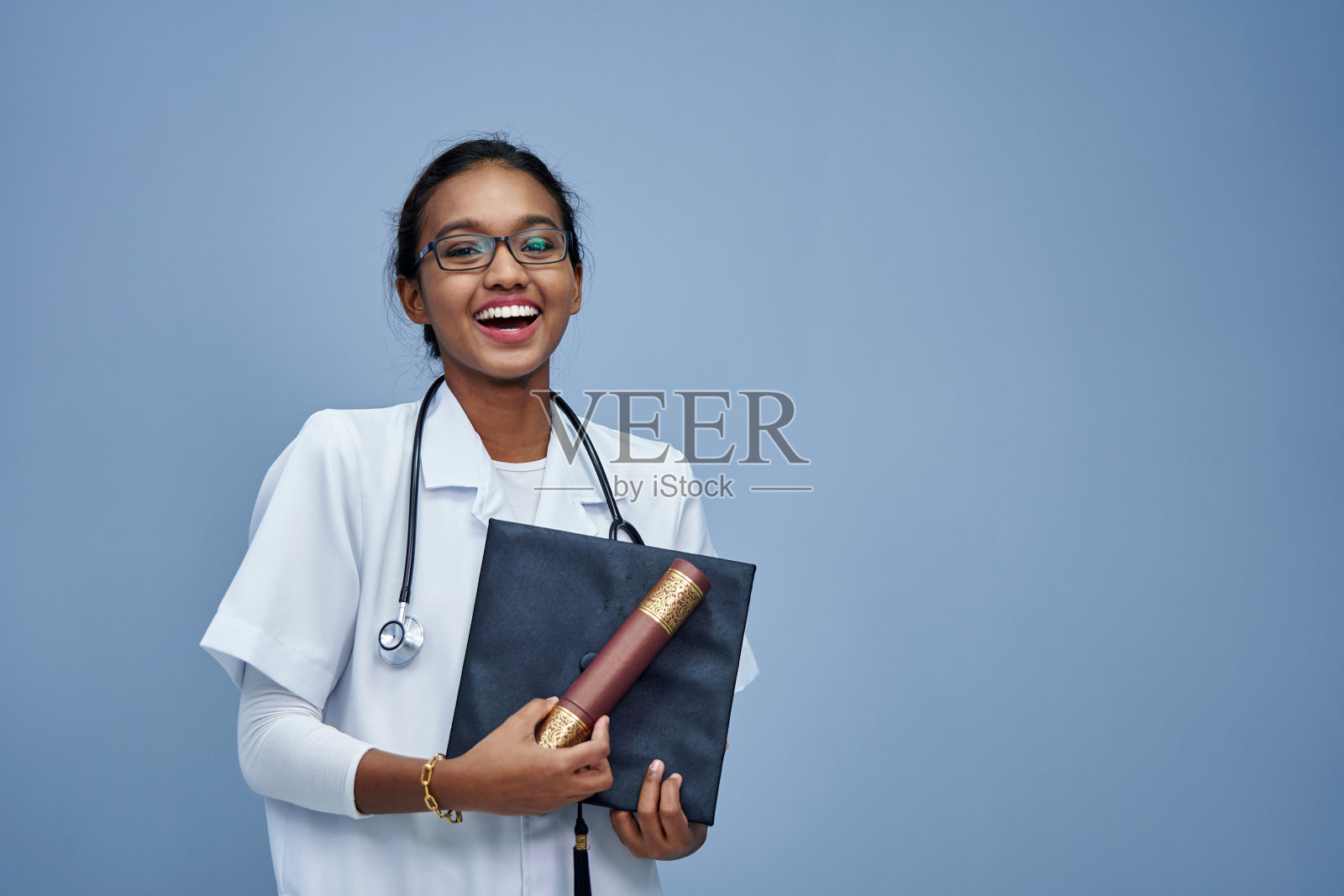 穿着白大褂、手持听诊器的女医生。照片摄影图片