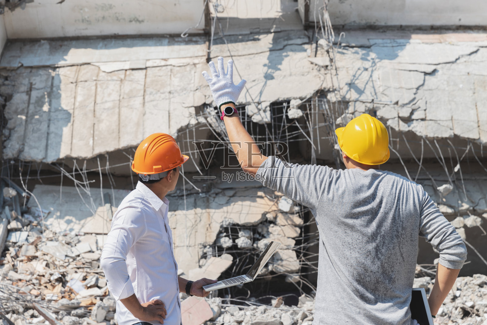 拆迁监理与承包人讨论拆迁建筑。照片摄影图片