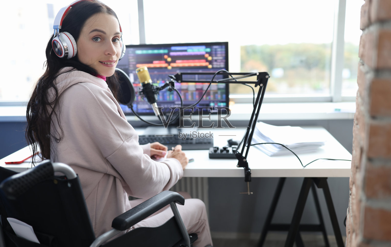 一名残疾妇女坐在轮椅上在演播室担任电台主持人照片摄影图片