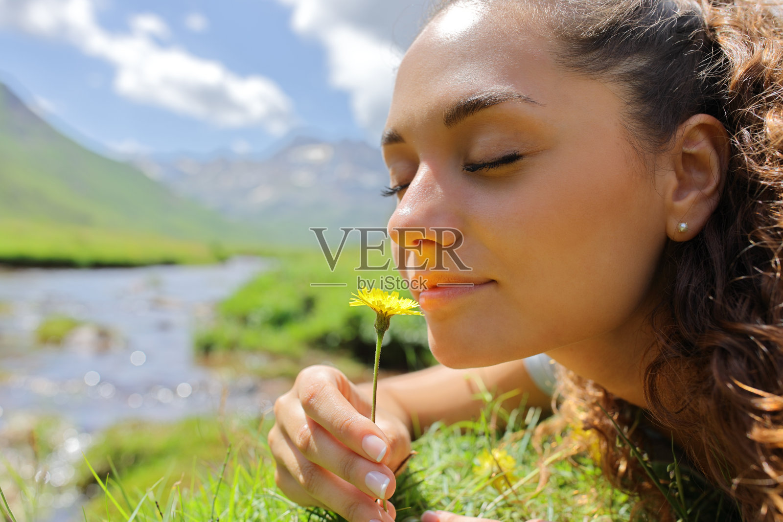 在山上闻花的女人照片摄影图片