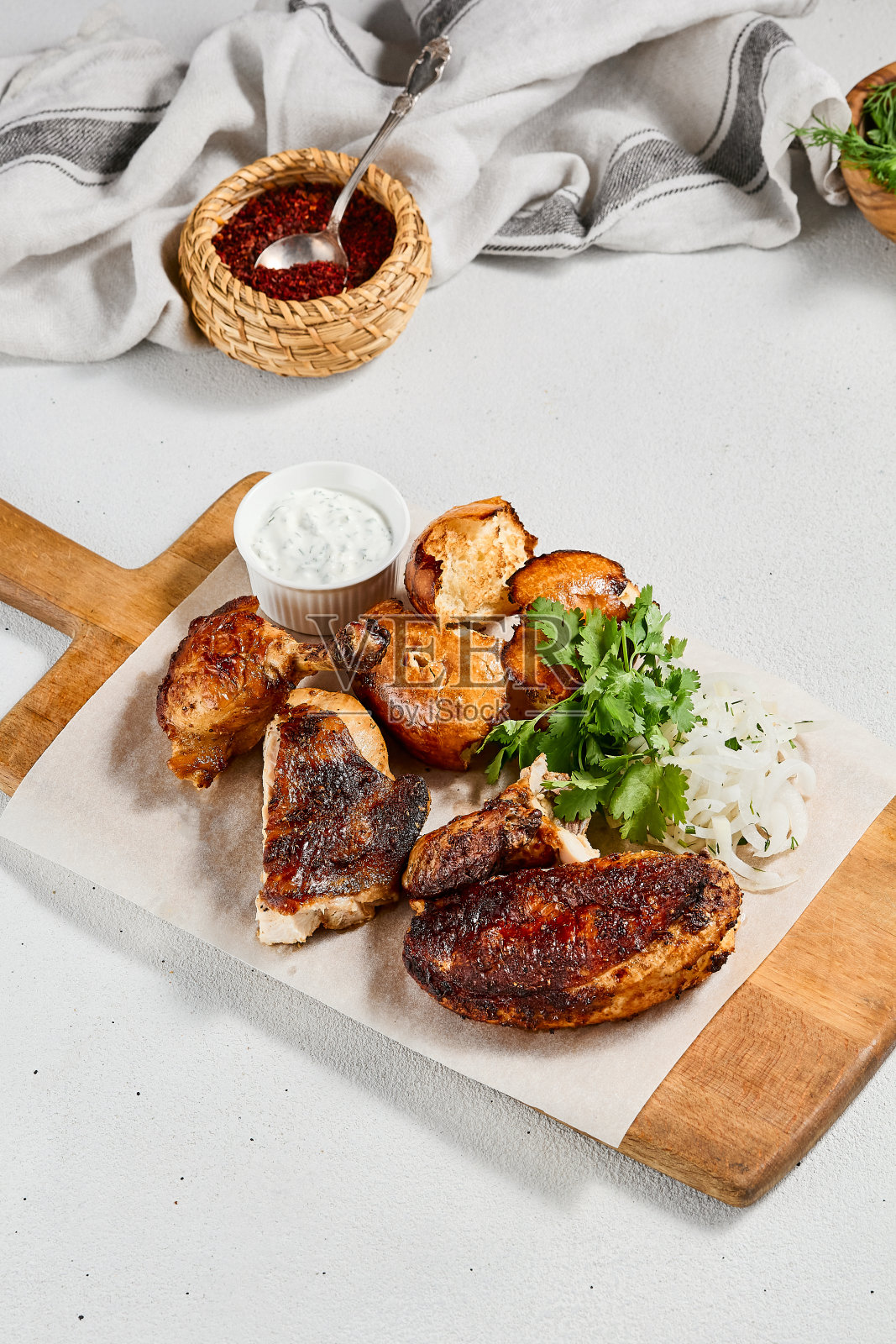 木盘烤鸡配香料和香草。传统的高加索食物——鸡tabaka。烤鸡配面包和酱汁在混凝土背景。照片摄影图片