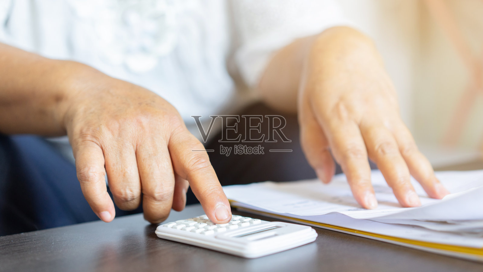 近高级妇女手用计算器计算关于退休后在家理财的养老生活方式的理财概念照片摄影图片