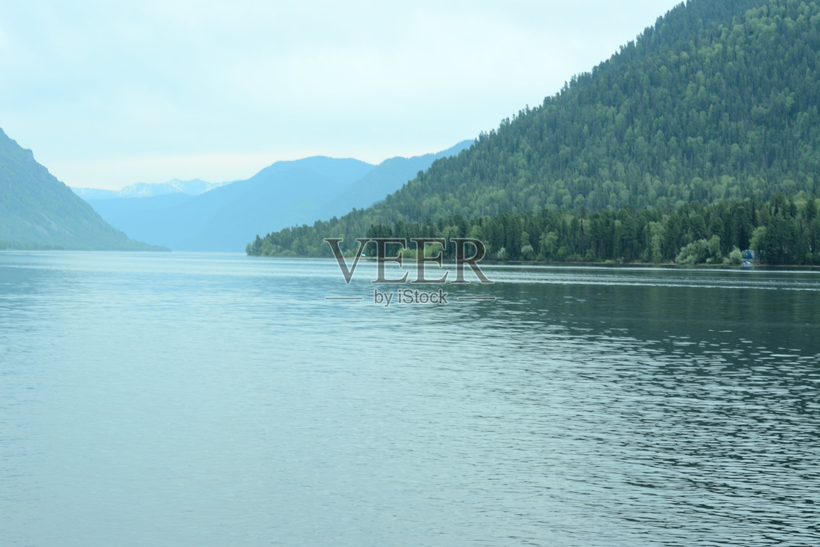 黄昏时分，高山山坡上长满了针叶林，这是一个美丽的湖泊。照片摄影图片