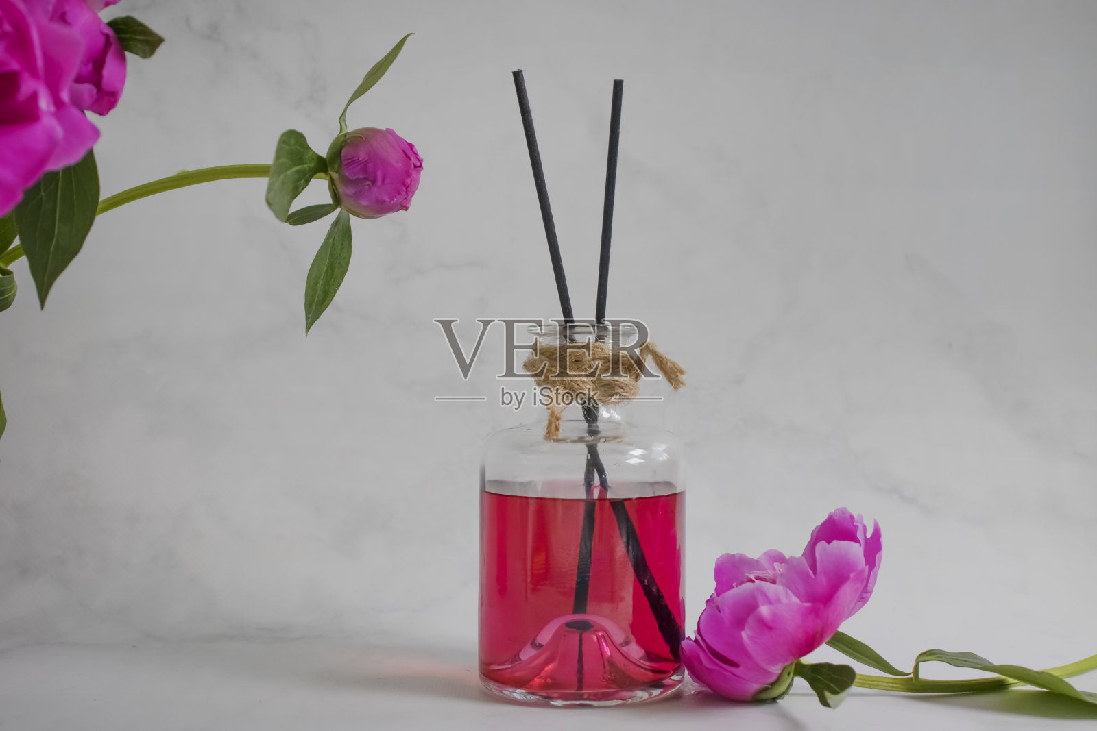 家里的香水，淡淡背景上的牡丹花照片摄影图片