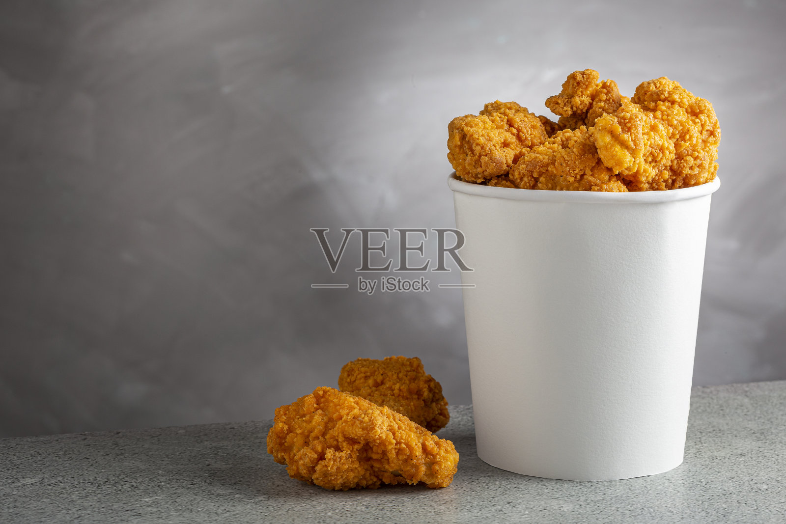 桶里脆脆的炸鸡。鸡斗。照片摄影图片