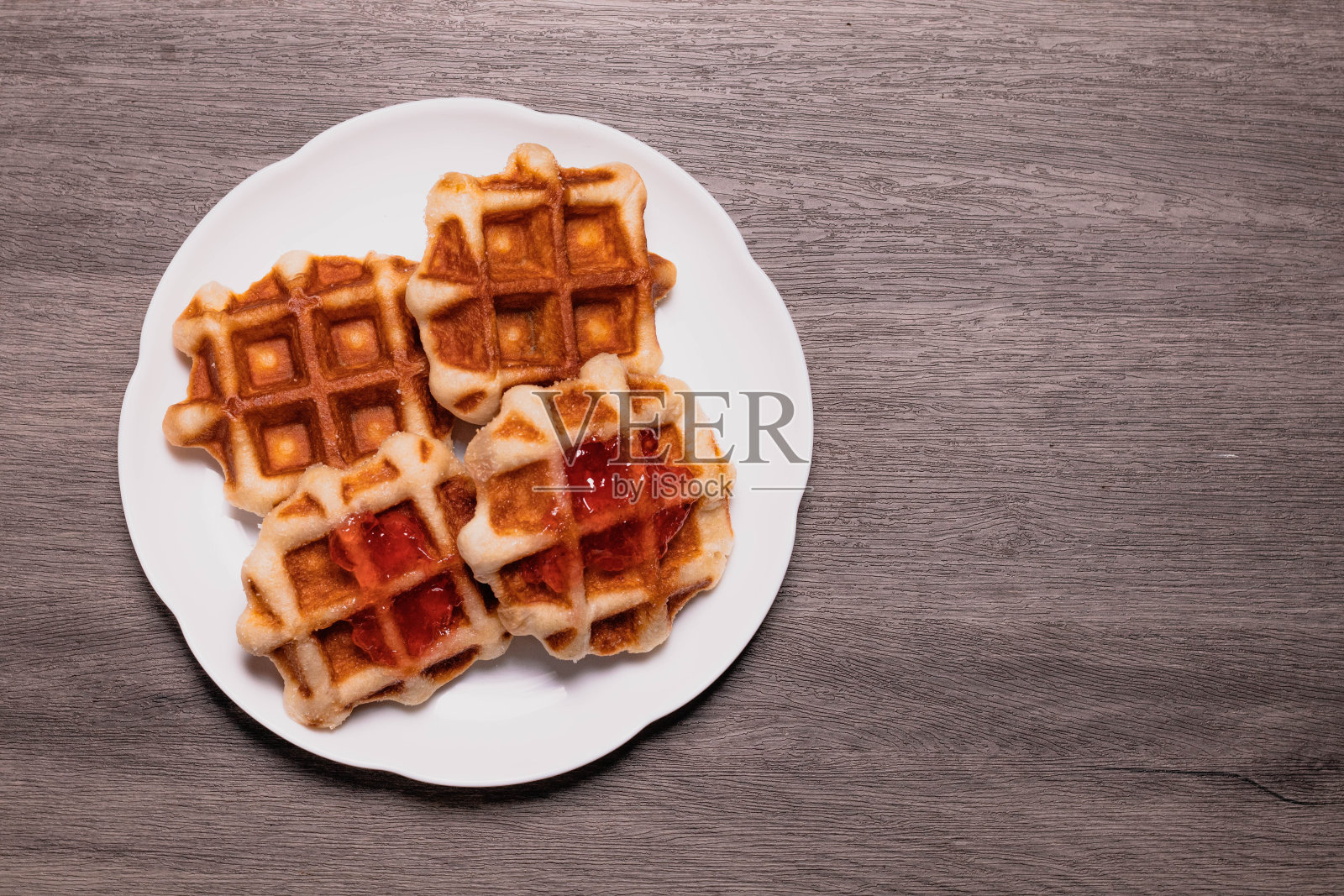 四个华夫饼放在一个白色盘子里。和灰色背景。照片摄影图片