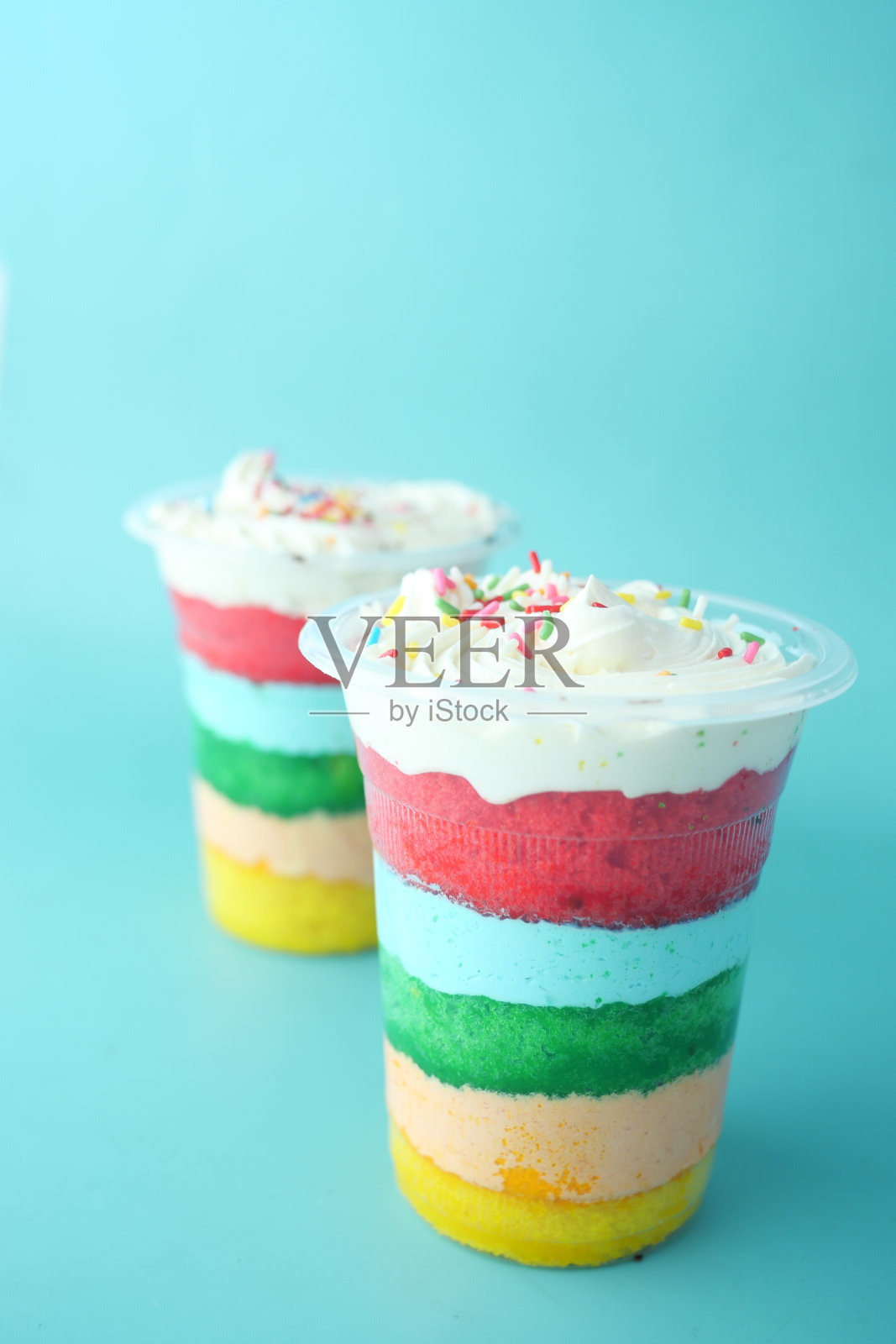 彩虹色蛋糕在一个塑料容器在桌子上照片摄影图片