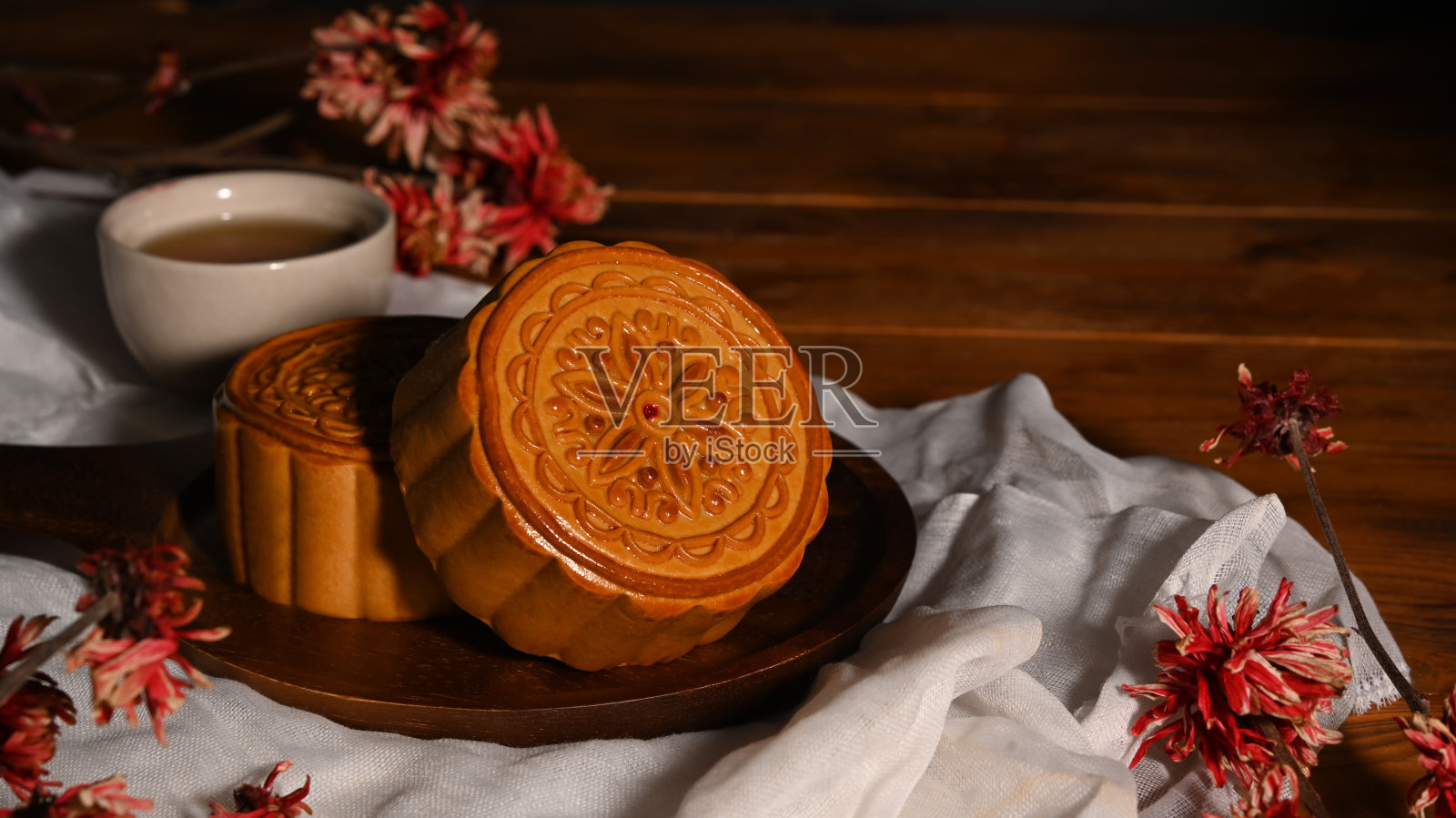 中国传统的中秋月饼和茶放在质朴的木桌上。照片摄影图片