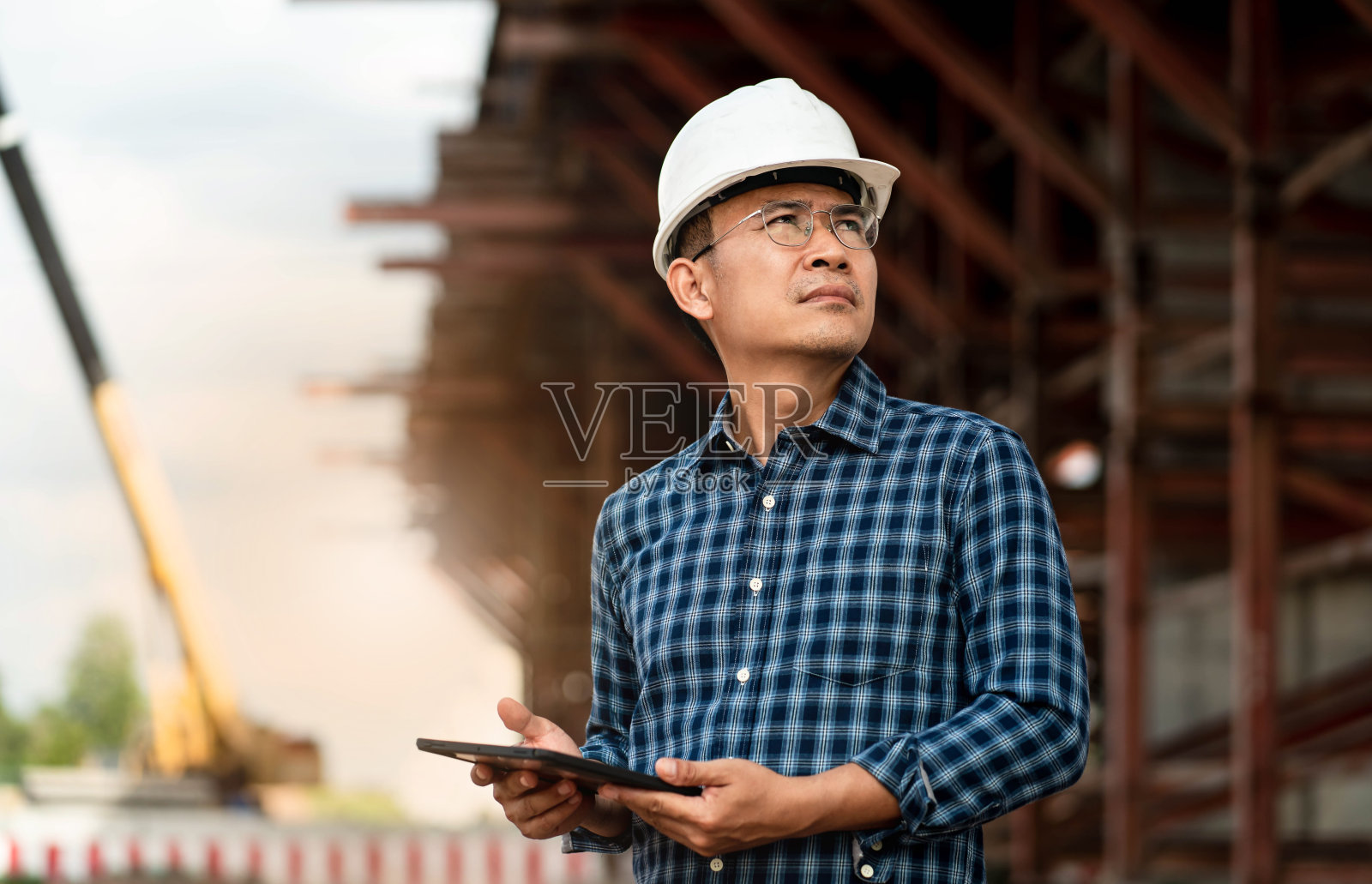 建筑工程师在工厂工作，用电脑检查机械设备。照片摄影图片