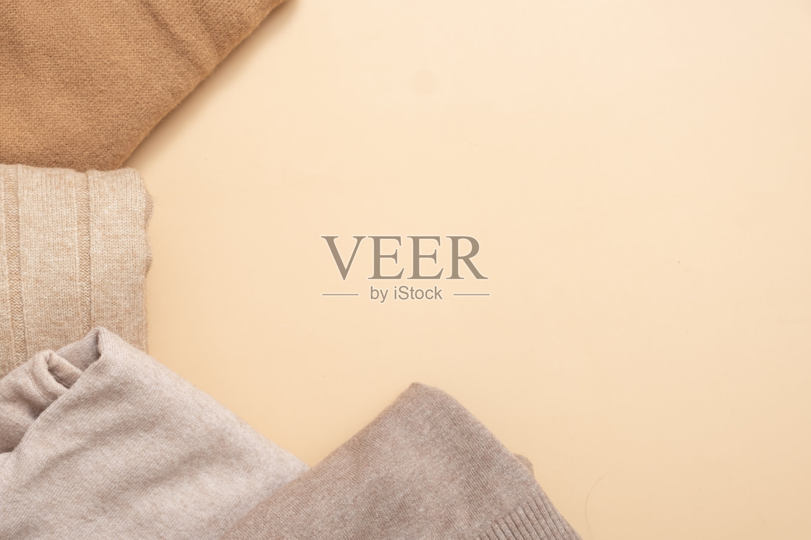 框架从舒适的针织毛衣在米色背景。温馨的概念与拷贝空间照片摄影图片