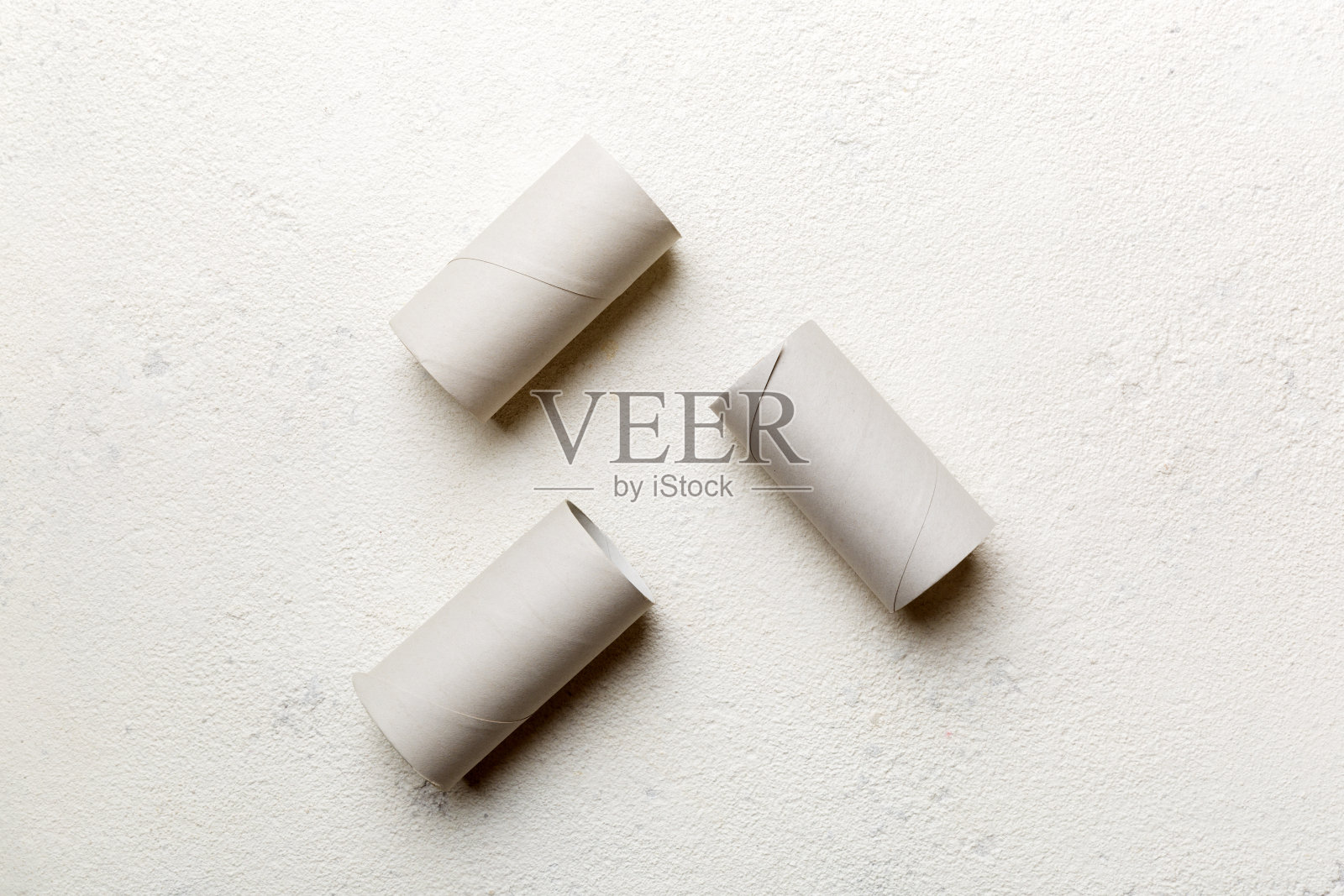 彩色背景上的空卫生纸卷。可回收的纸管，金属插头端由牛皮纸或纸板制成照片摄影图片