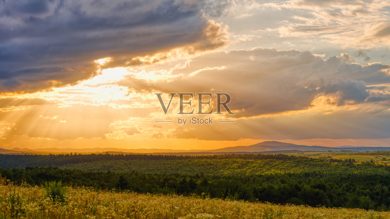 阳光透过山林上的乌云照片摄影图片