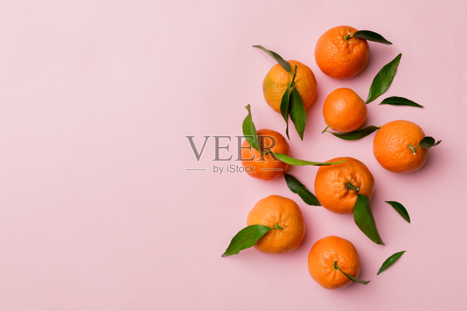 许多新鲜成熟的普通话与绿色的叶子上彩色的背景，俯视图，文字的空间照片摄影图片