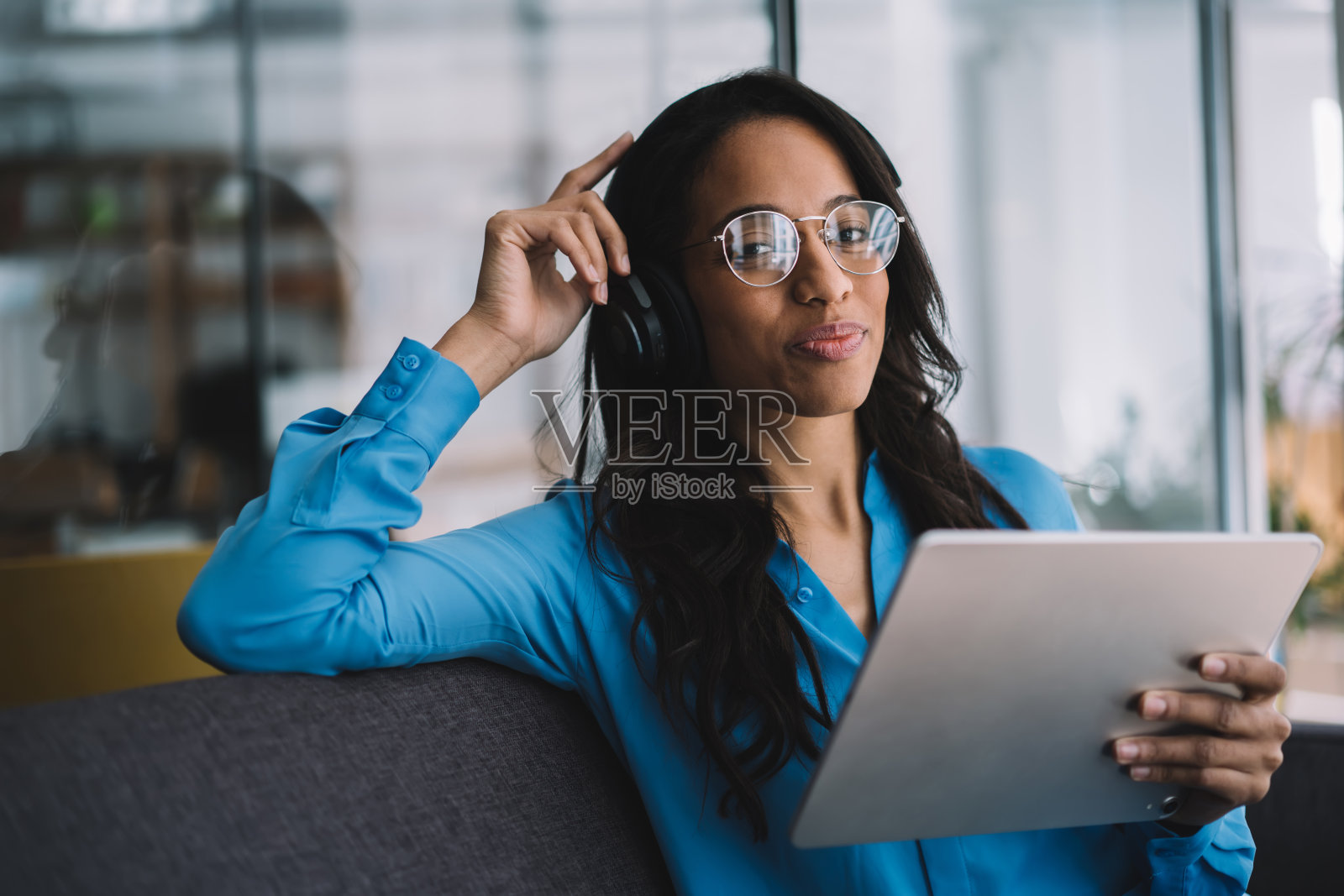 高兴的非洲裔美国女性在办公室使用平板电脑照片摄影图片